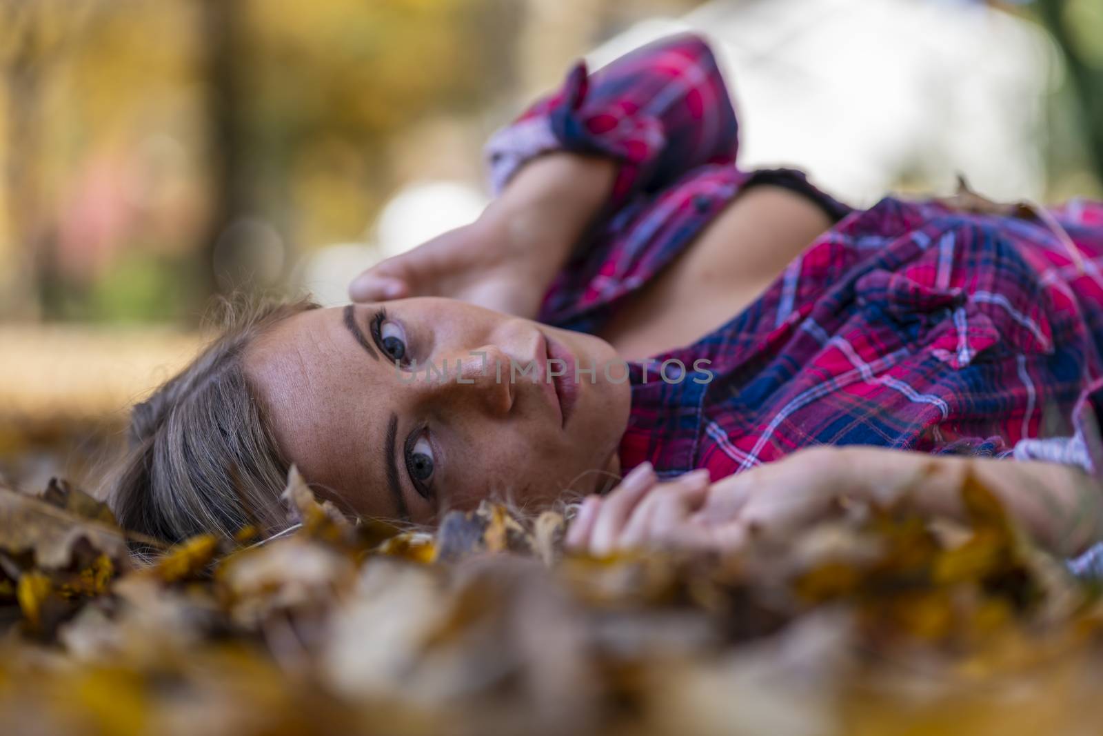 A gorgeous blonde model enjoys a Autumn day outdoors in a park