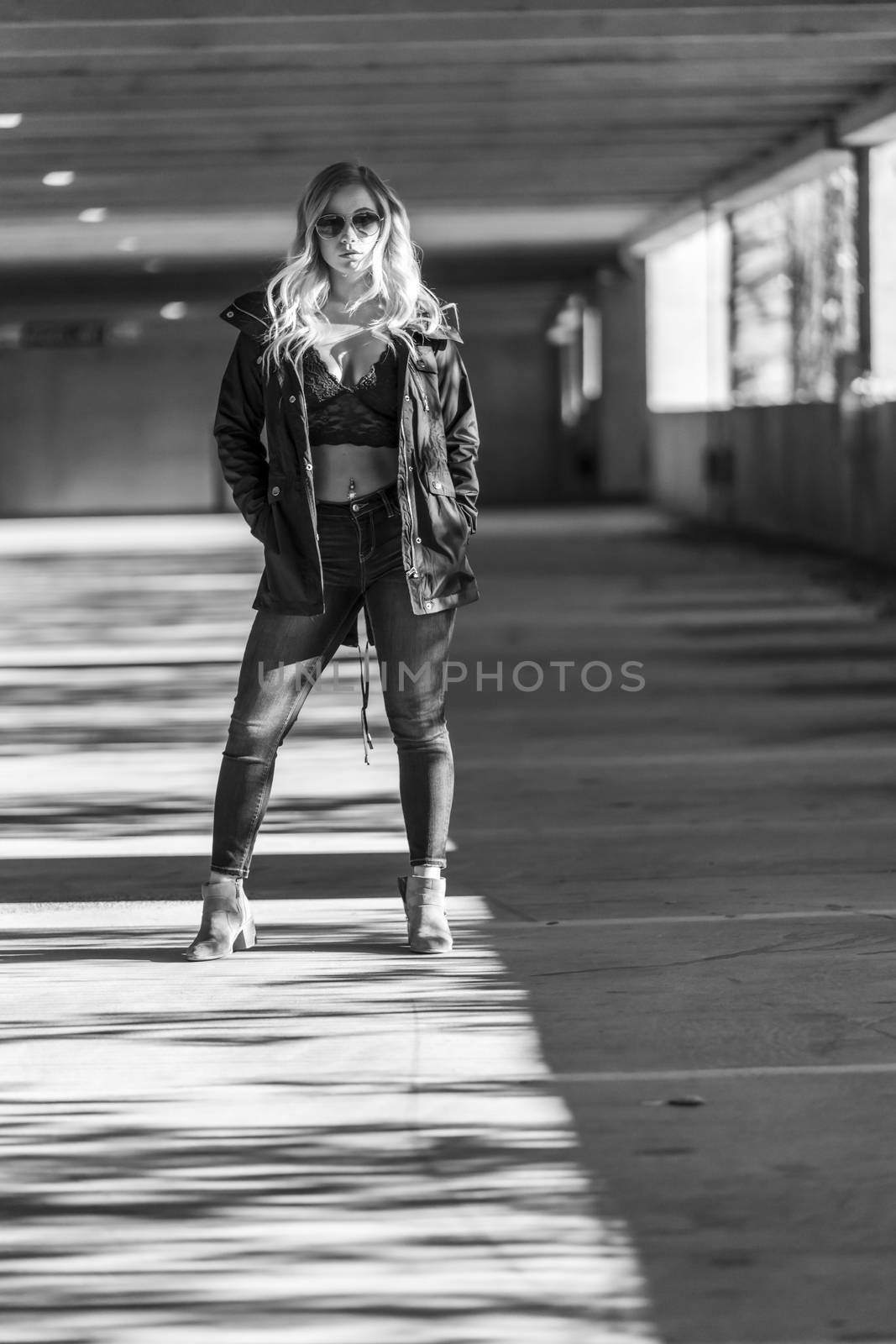 A gorgeous blonde model poses in a parking deck on an autumn day