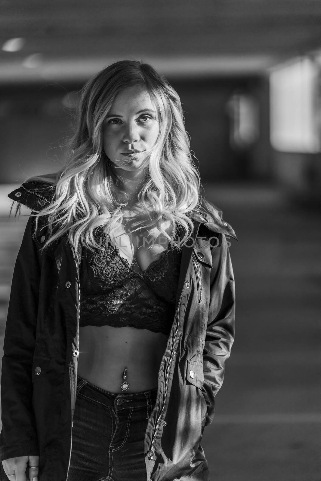 A gorgeous blonde model poses in a parking deck on an autumn day