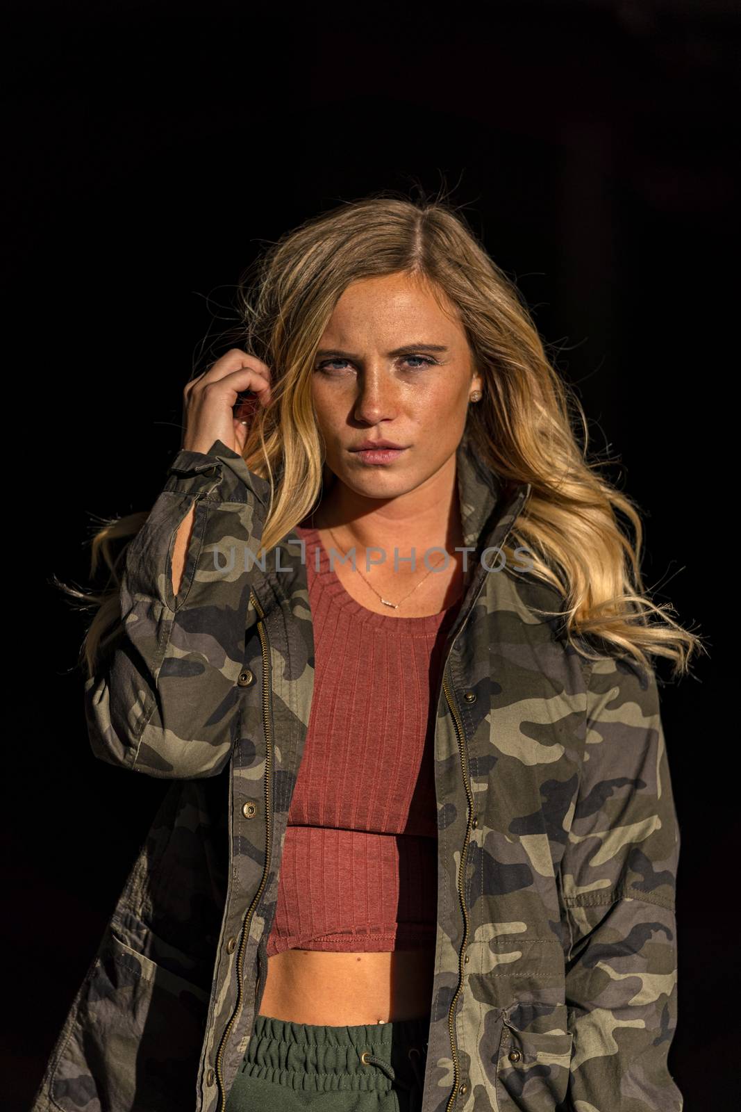 A gorgeous blonde model poses in a parking deck on an autumn day