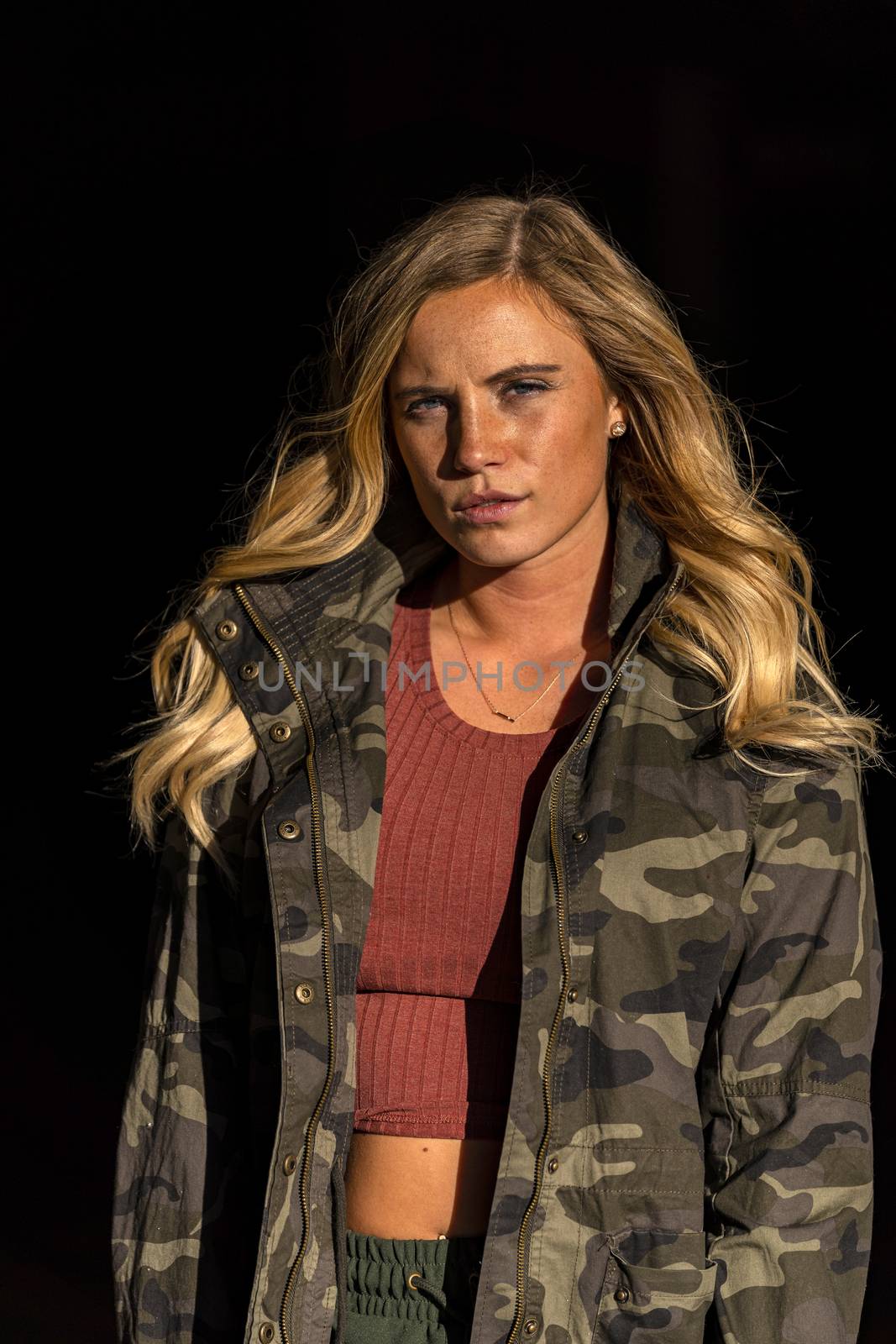 A gorgeous blonde model poses in a parking deck on an autumn day