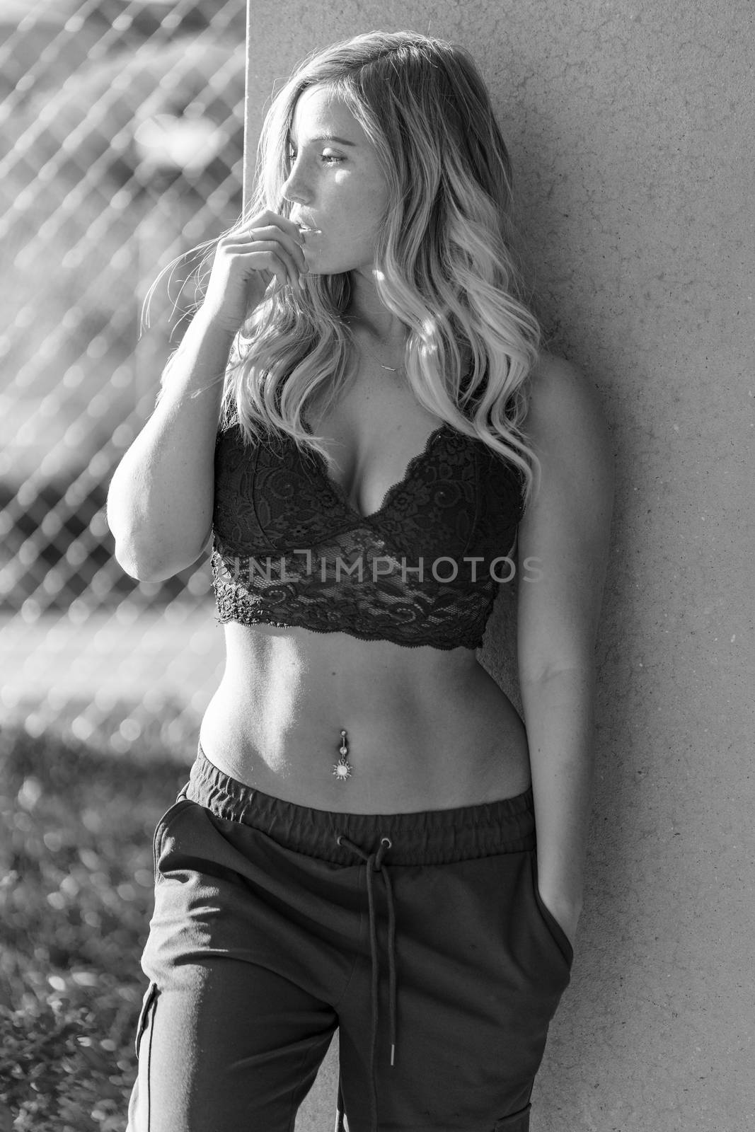A gorgeous blonde model poses in a parking deck on an autumn day