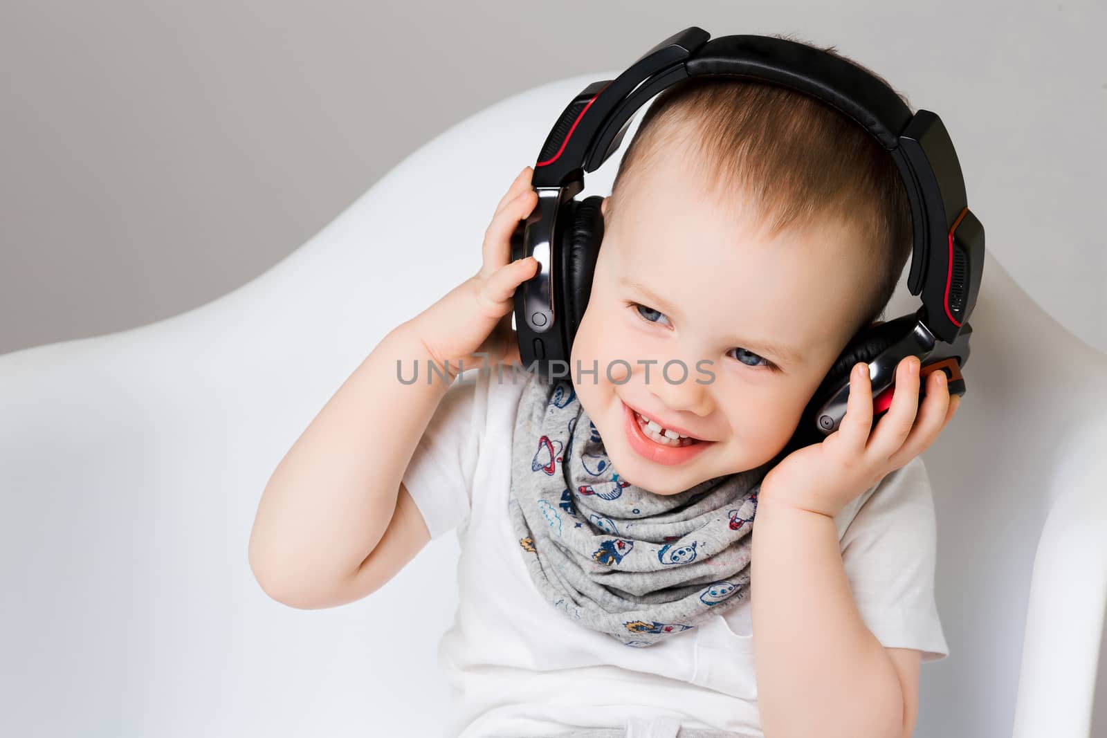 Fun smiling little boy listening music in earphones. by StudioLucky