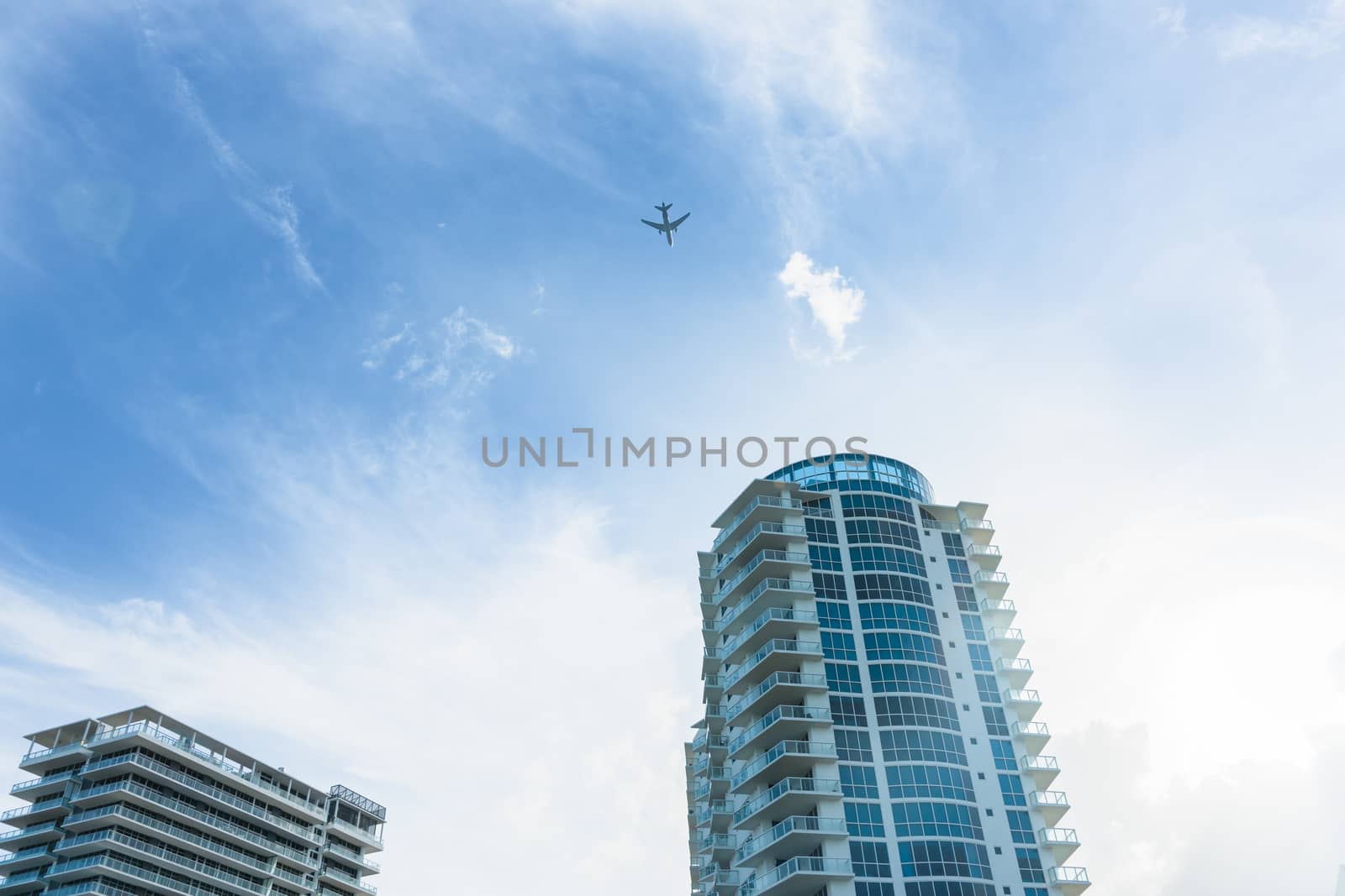 High-rise apartment buildings with passenger plane flying past high above