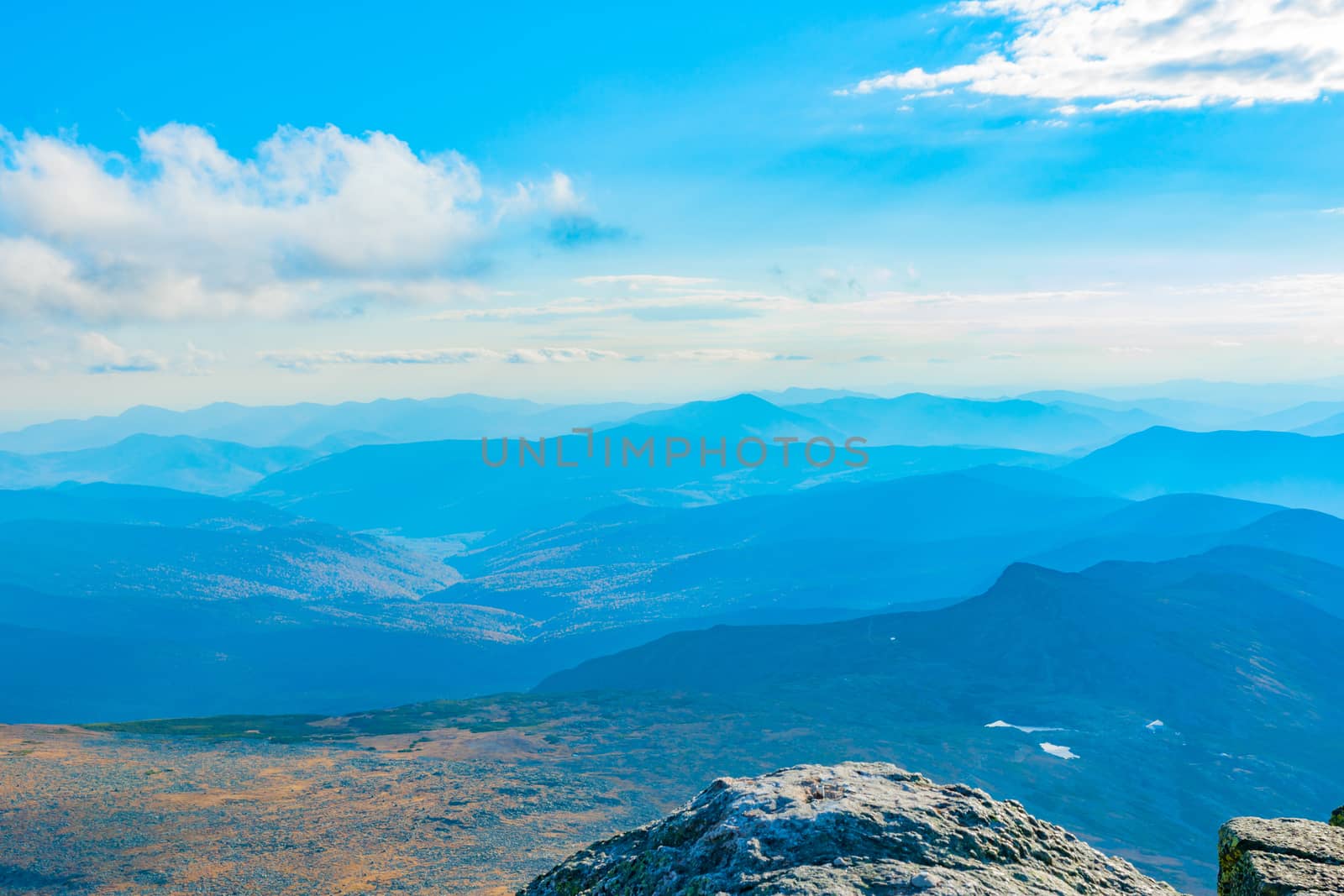View from top of Mount Washington across mountainous landscape in New Hampshire USA.