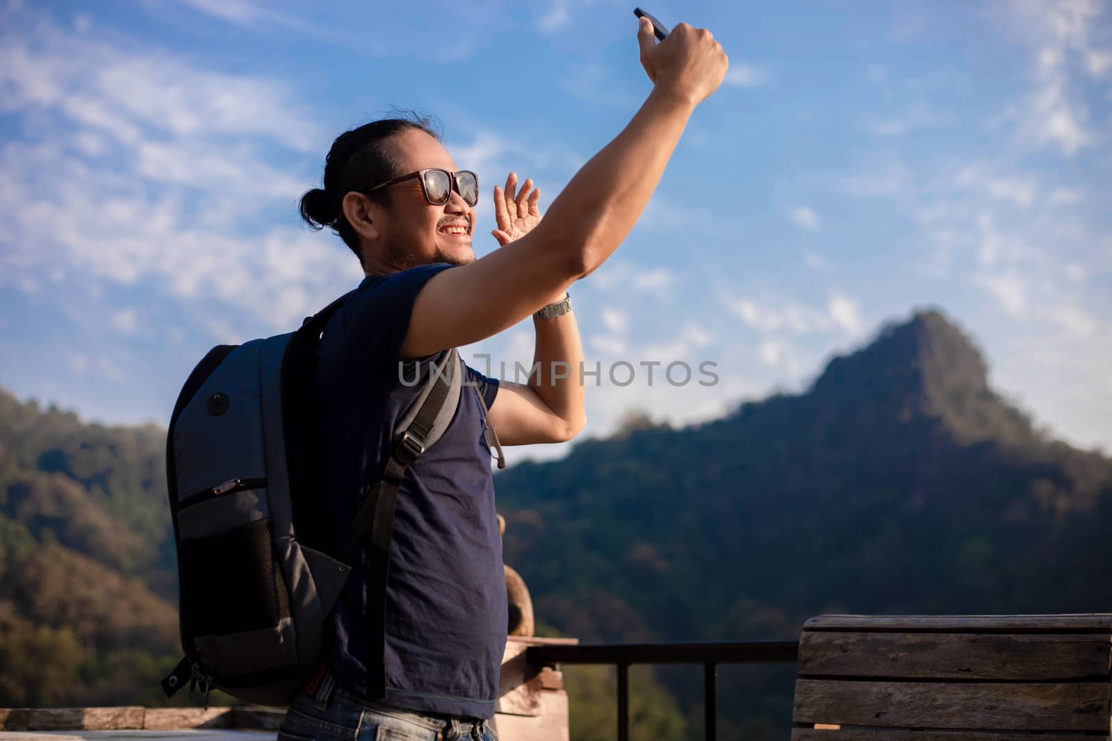 Asian man tourist is using a mobile phone to take a selfie for s by Tuiphotoengineer