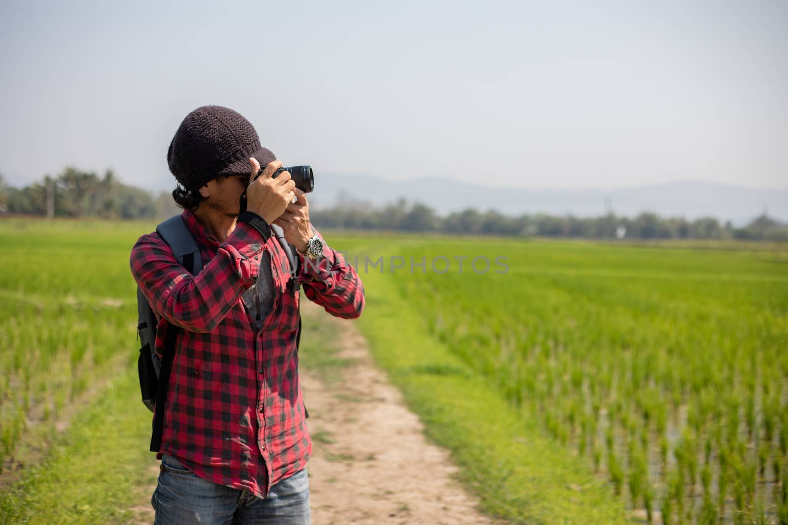 Asian man tourist is using a camera for taking pictures of scenery and mountain .Relax time on holiday concept travel