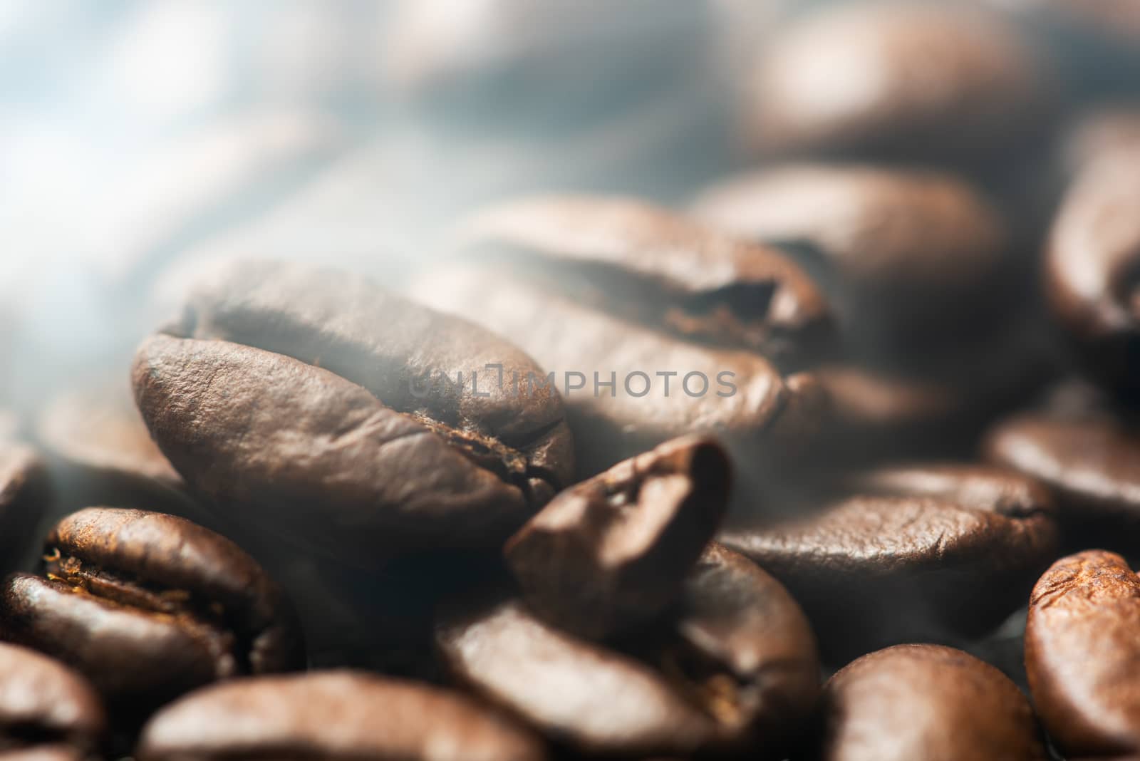 Heap of roasted coffee beans close-up view with smoke