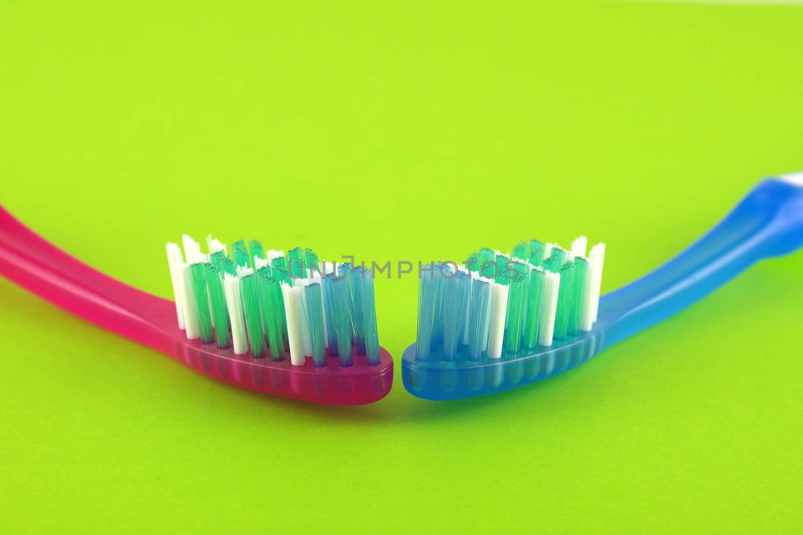 Two tooth-brushes over bright green