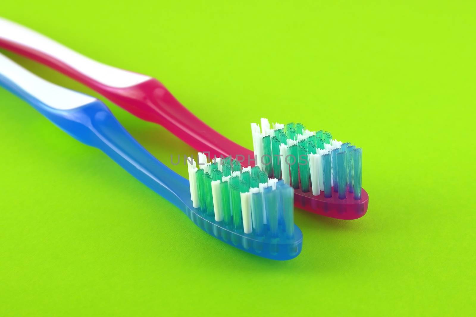 Two tooth-brushes over bright green