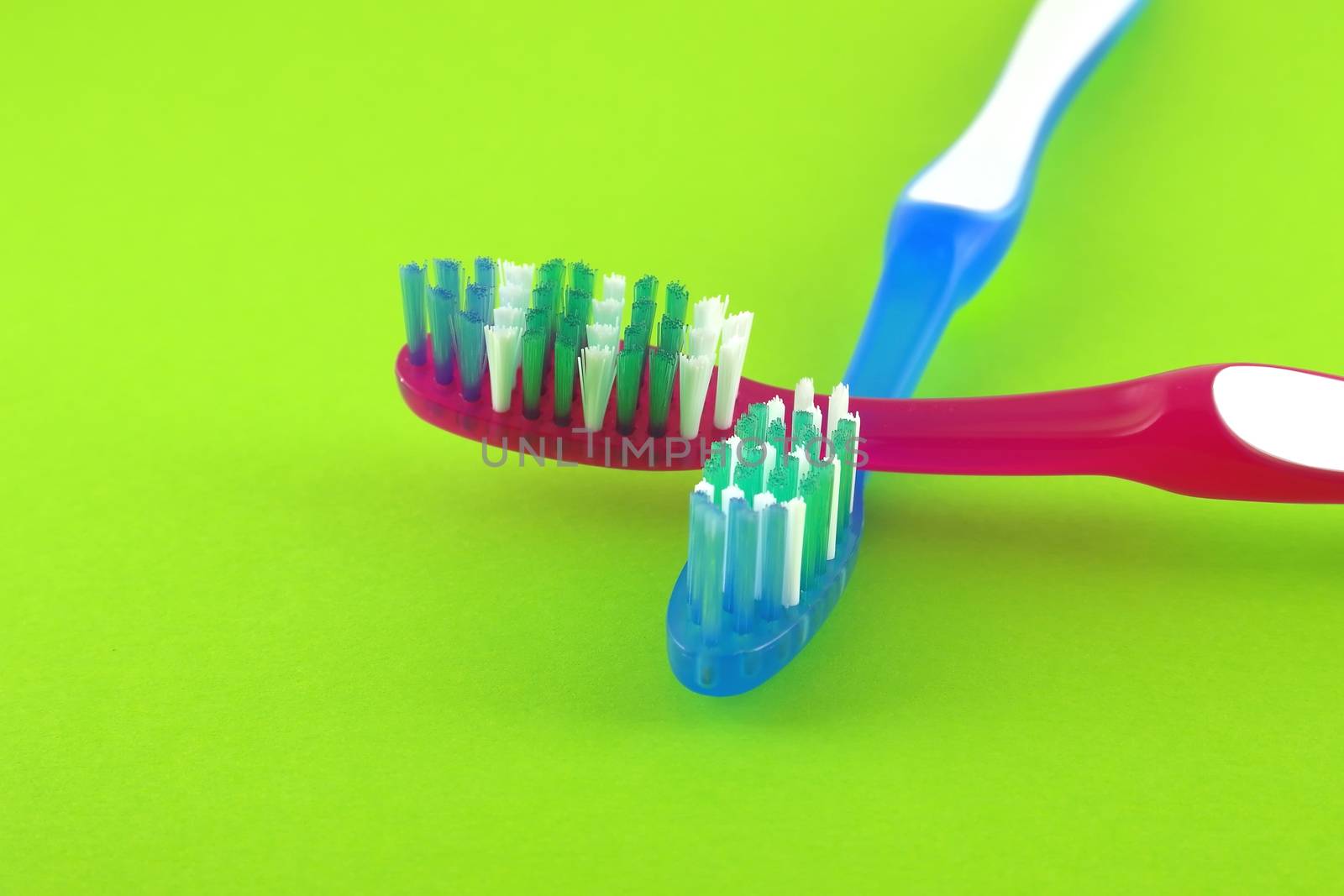 Two tooth-brushes over bright green