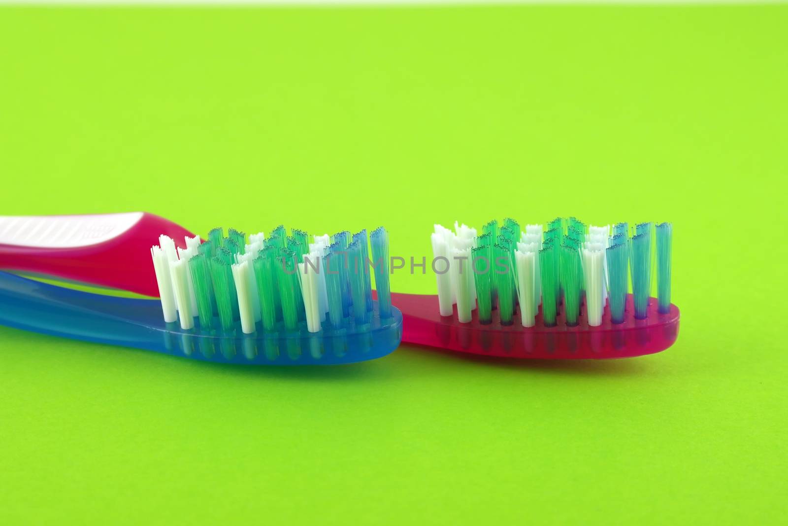 Two tooth-brushes over bright green