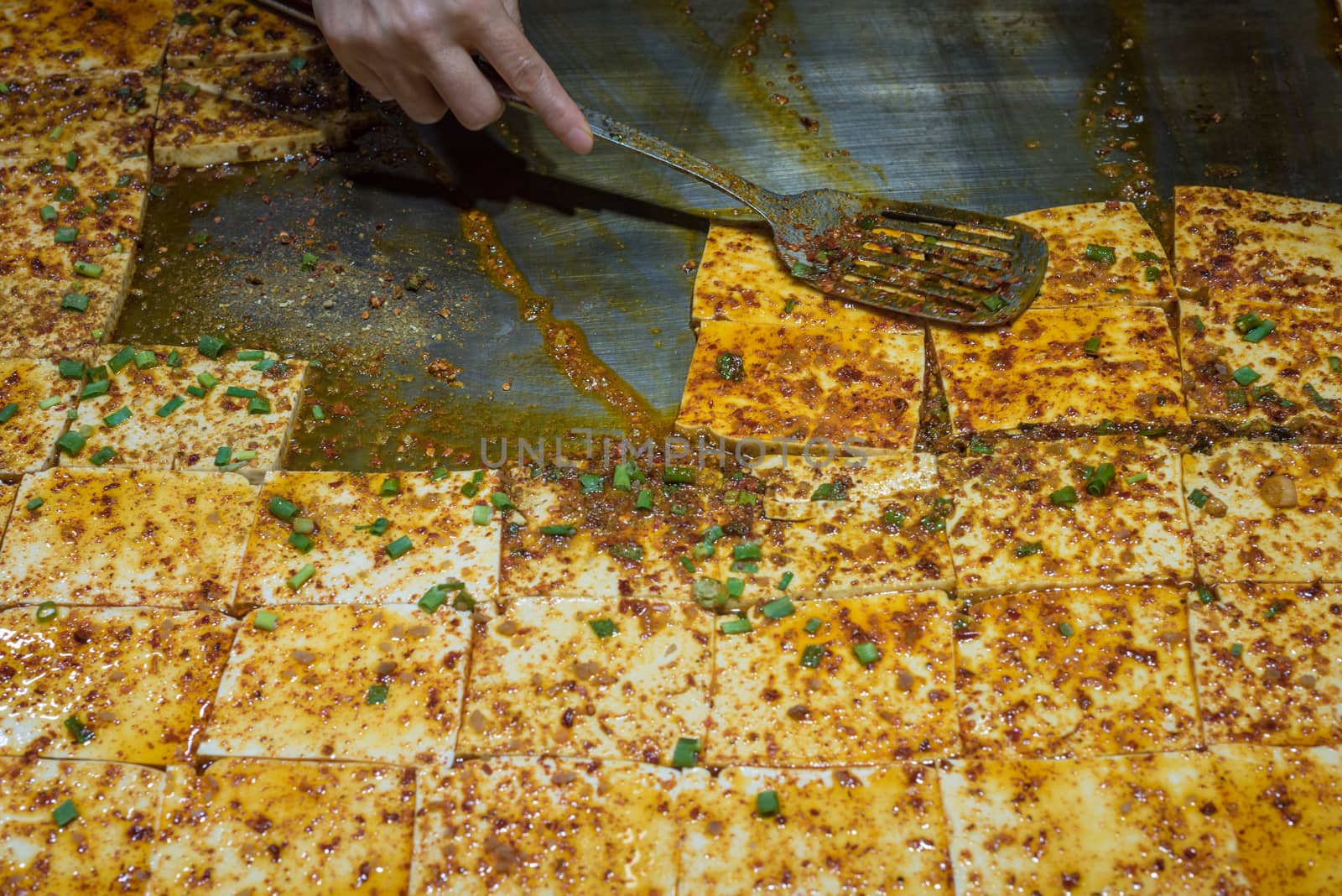 Cooking stir-fried tofu with spicy sauce in a chinese street market, Chengdu, China