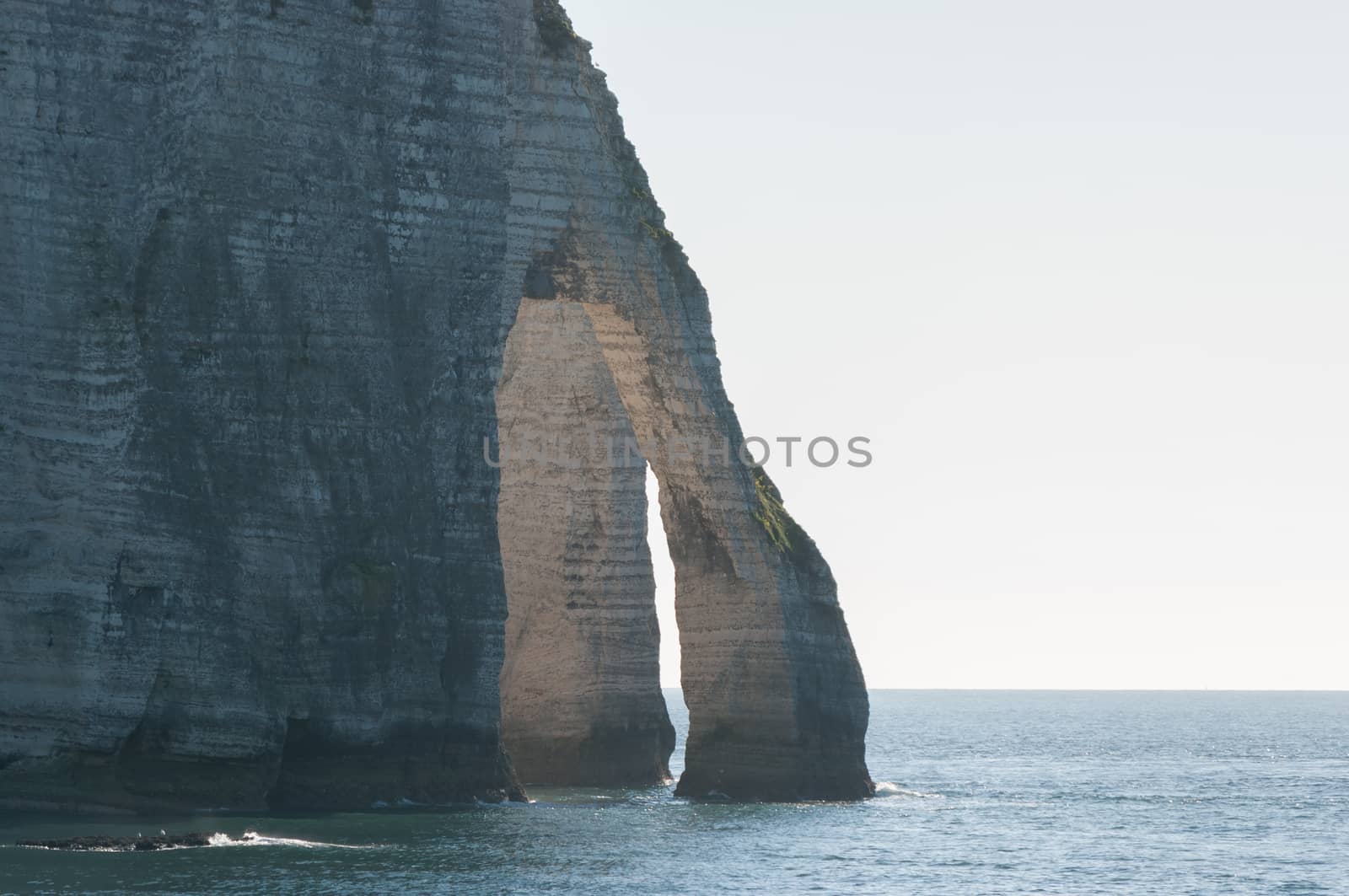 Natural stone arch on chalk cliffs with the sea in Etretat, Normandy, France