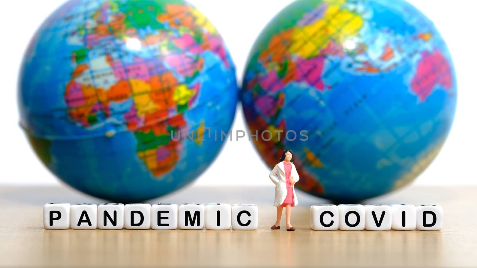 Pandemic corona virus conceptual miniature people photography – word beads alphabet covid with doctor figure by Macrostud