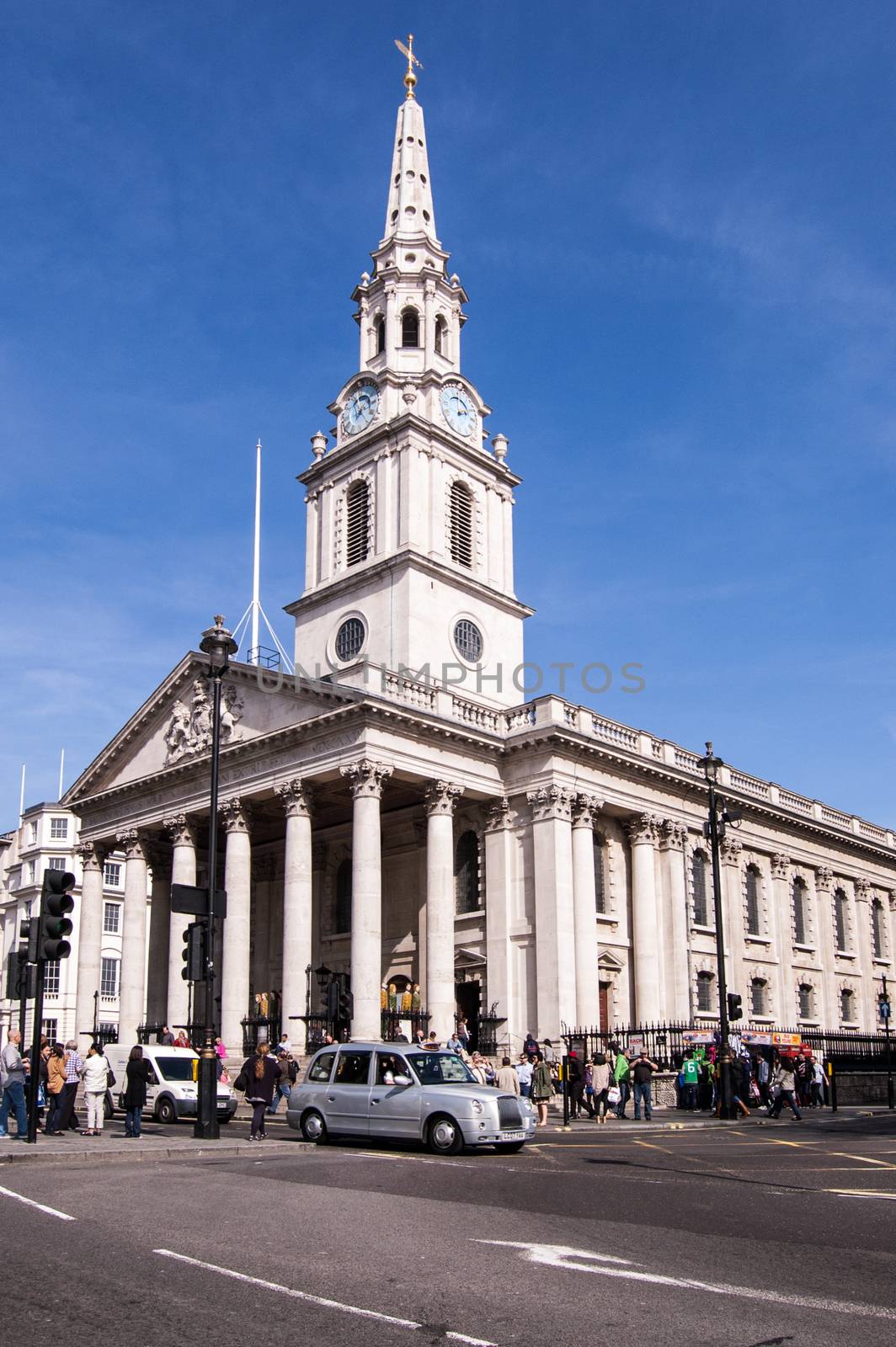 London, UK - March 25, 2012:  Traffic and pedestrians outside the landmark church of St Martin in the Fields in Trafalgar Square, London on a sunny spring afternoon.