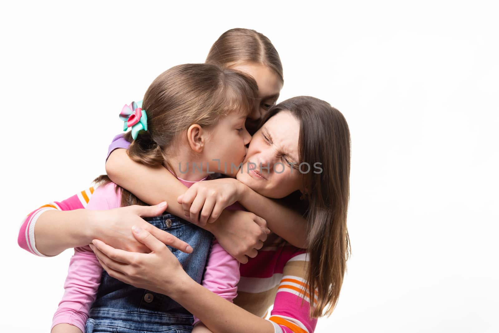 Two daughters kiss mom, isolated on white background