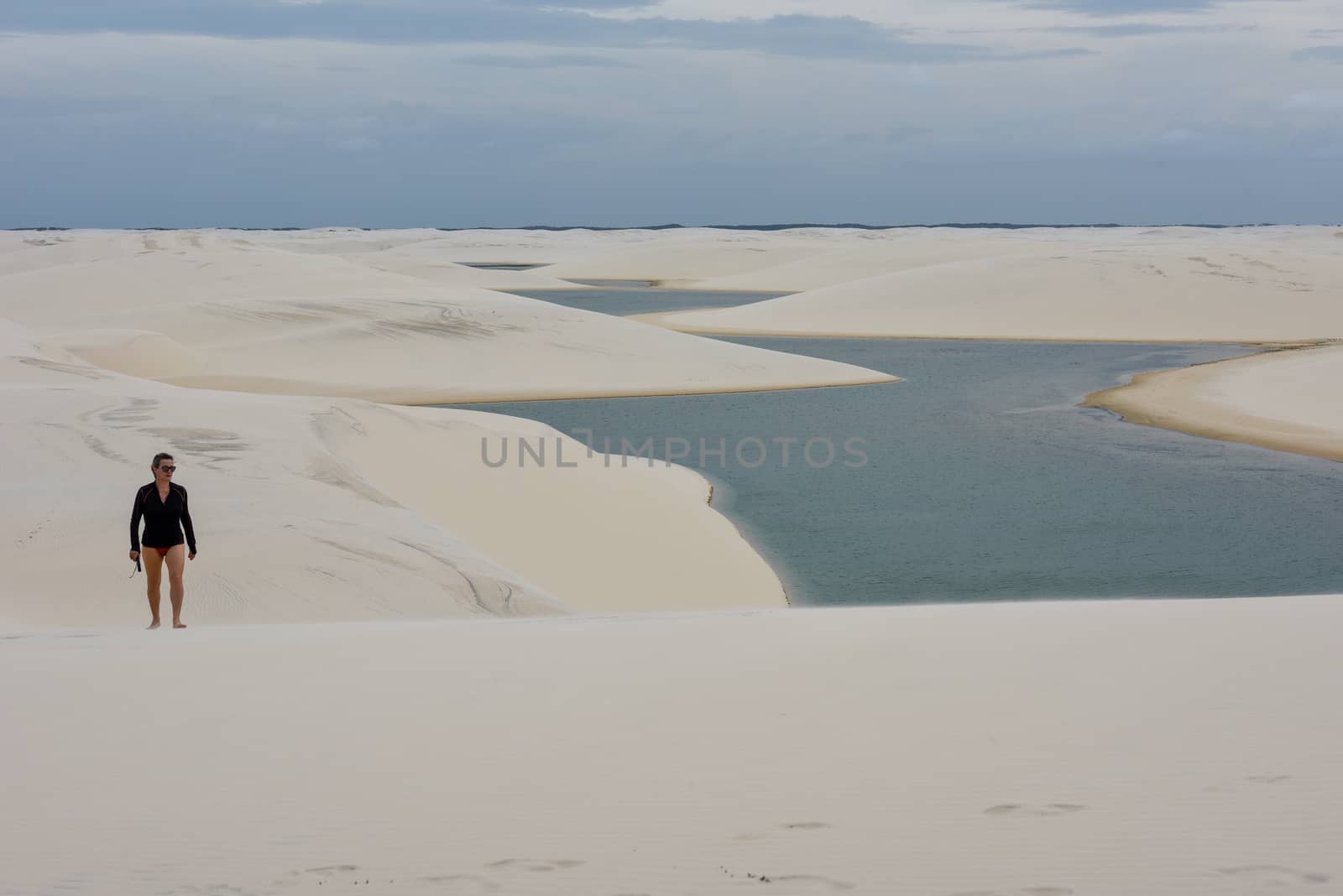 Atins, Brazil - 12 January 2019: woman walking on the dunes at Lencois Maranhenese National Park in Brazil