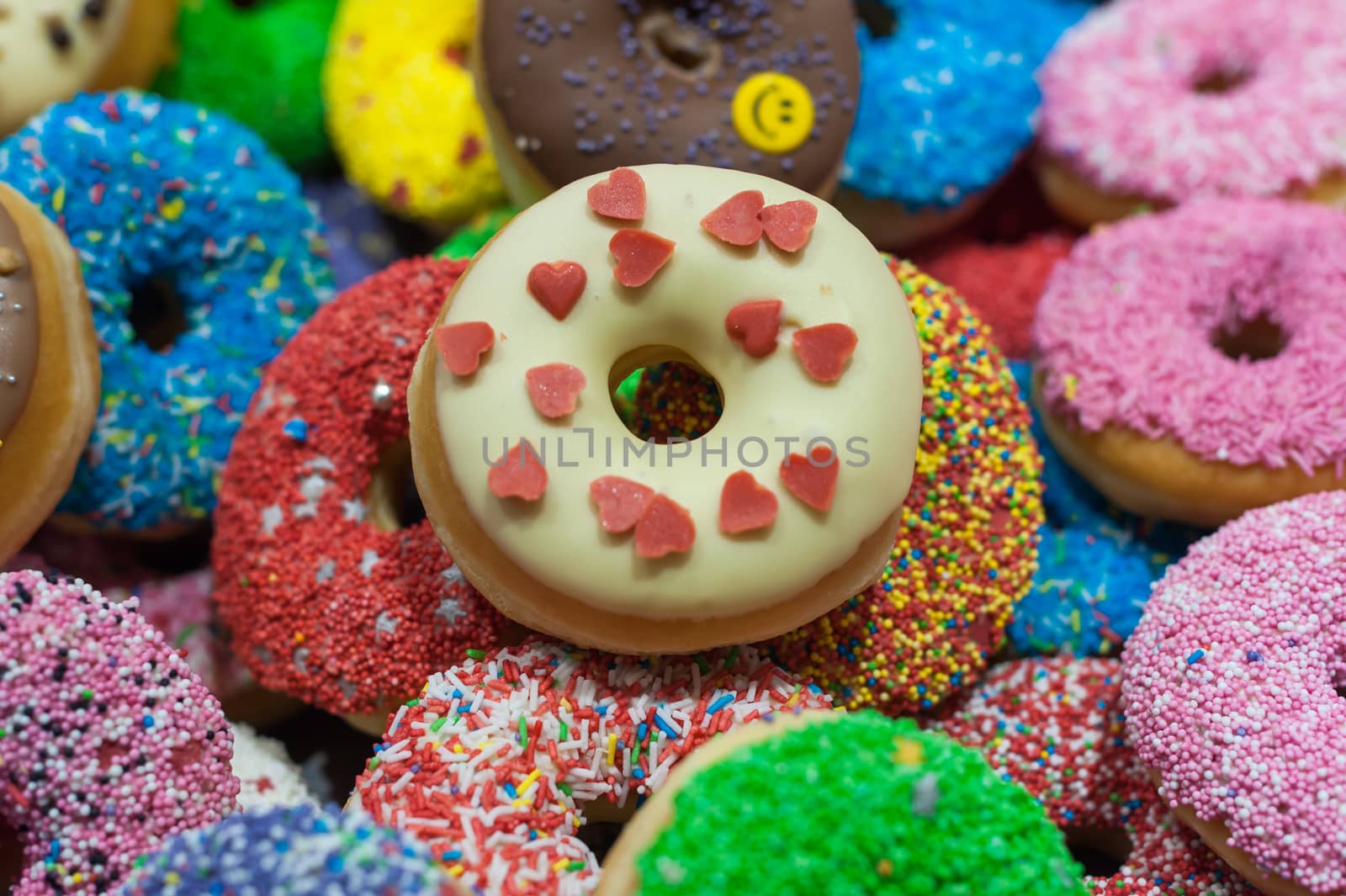 Bunch of multicolor donuts closeup on a market