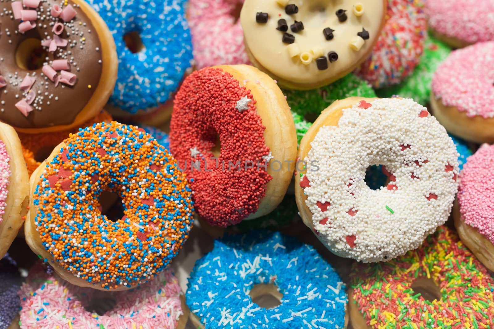 Bunch of multicolor donuts closeup on a market