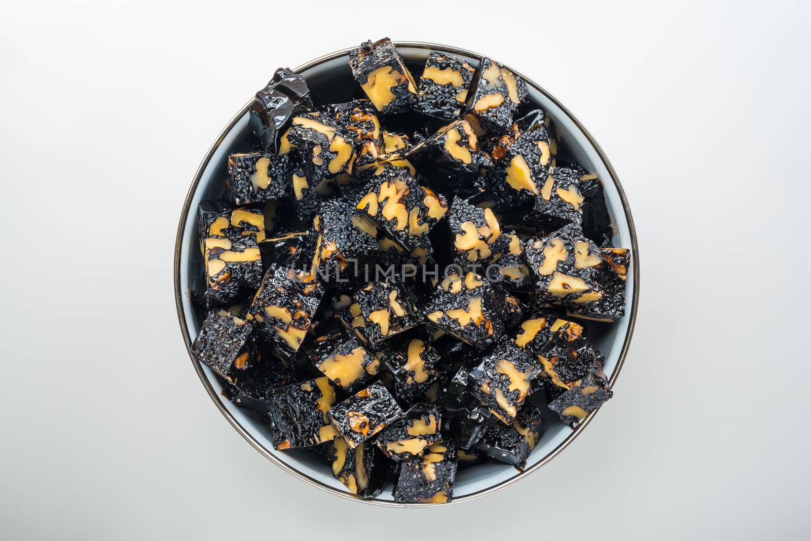 Ejiao Gao walnut and sesame donkey hide gelatin cubes bowl on a white table for use in chinese traditional medicine