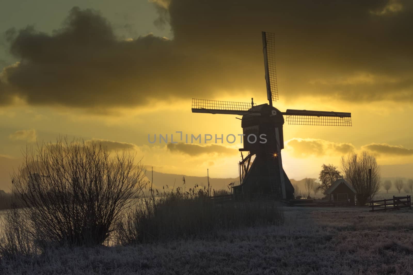 Windmill silhouette at the early morning sunrise in Netherlands