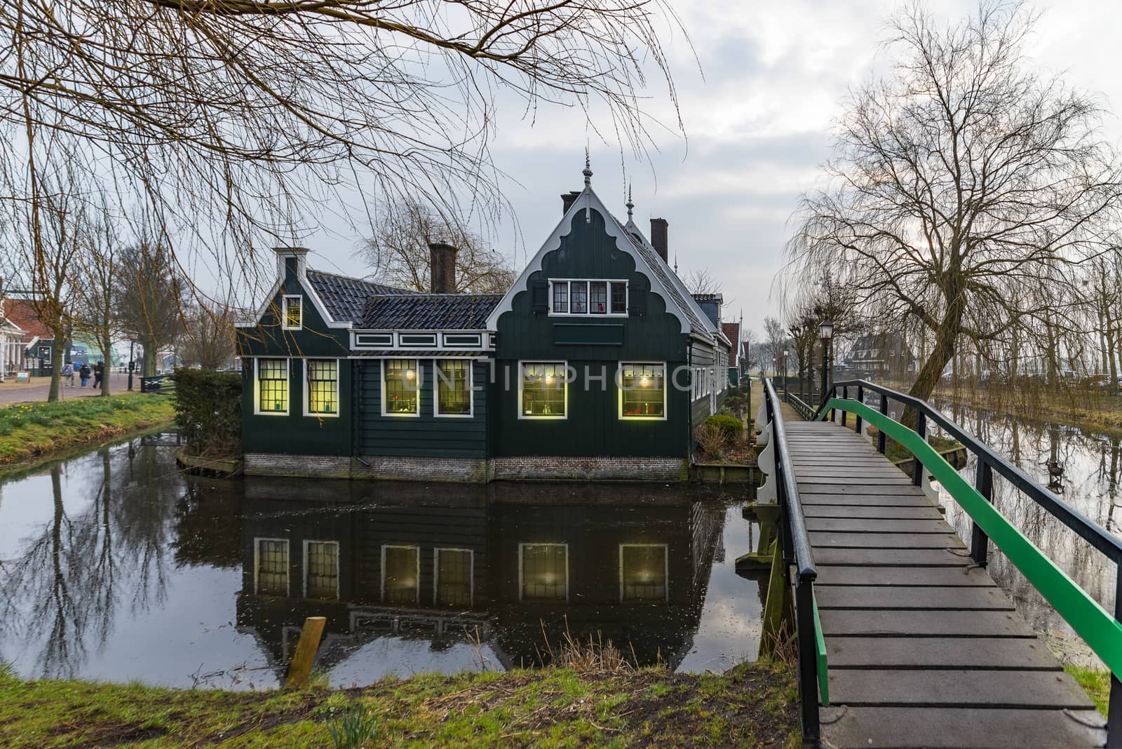 Beautiful and typical Dutch wooden houses architecture mirrored on the calm canal of Zaanse Schans located at the North of Amsterdam, Netherlands by ankorlight