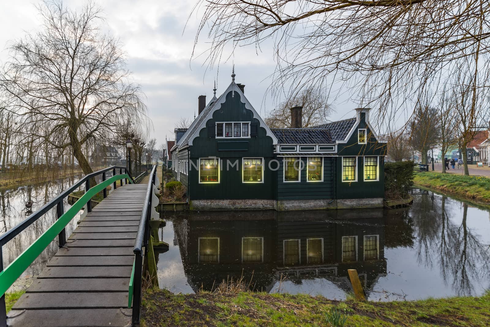 Beautiful and typical Dutch wooden houses architecture mirrored on the calm canal of Zaanse Schans located at the North of Amsterdam, Netherlands by ankorlight
