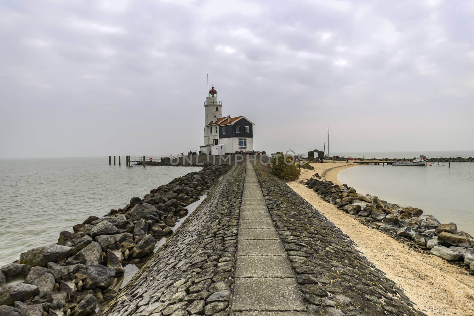 View of the white Marken island lighthouse under a foggy and cold skyline in the early morning, Netherlands