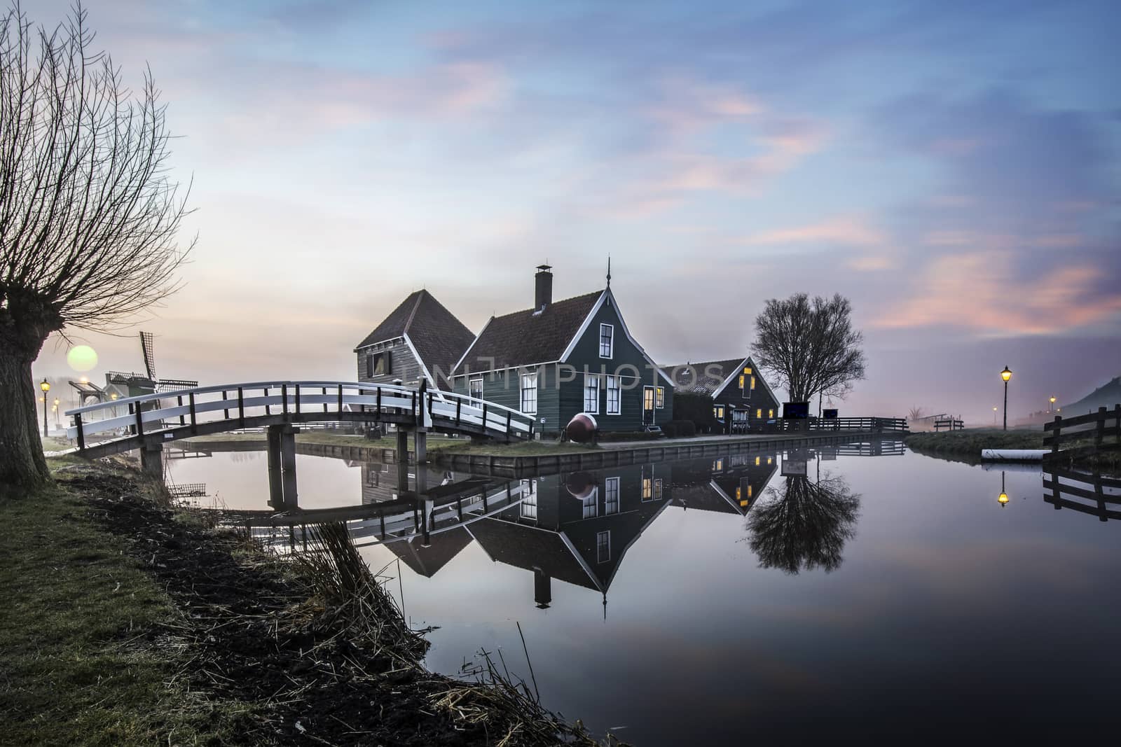 Beaucoutif typical Dutch wooden houses architecture mirrored on the calm canal of Zaanse Schans located at the North of Amsterdam, Netherlands by ankorlight