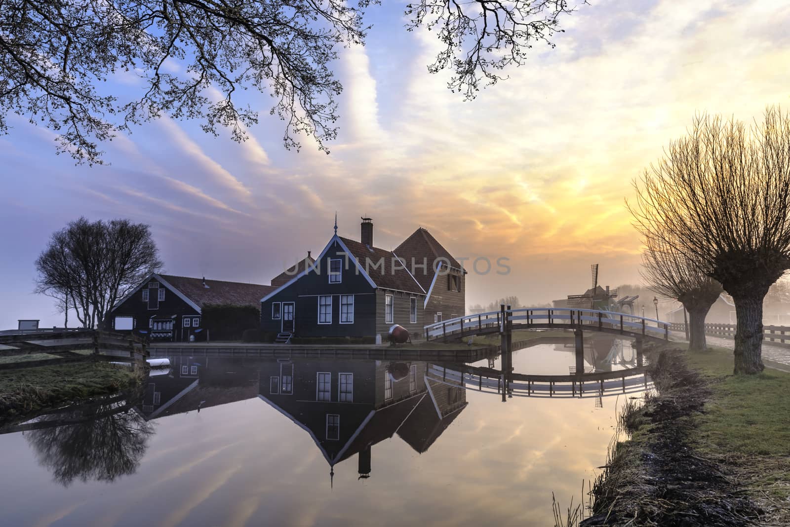 Beautiful and typical Dutch wooden houses architecture mirrored on the calm canal of Zaanse Schans located at the North of Amsterdam, Netherlands