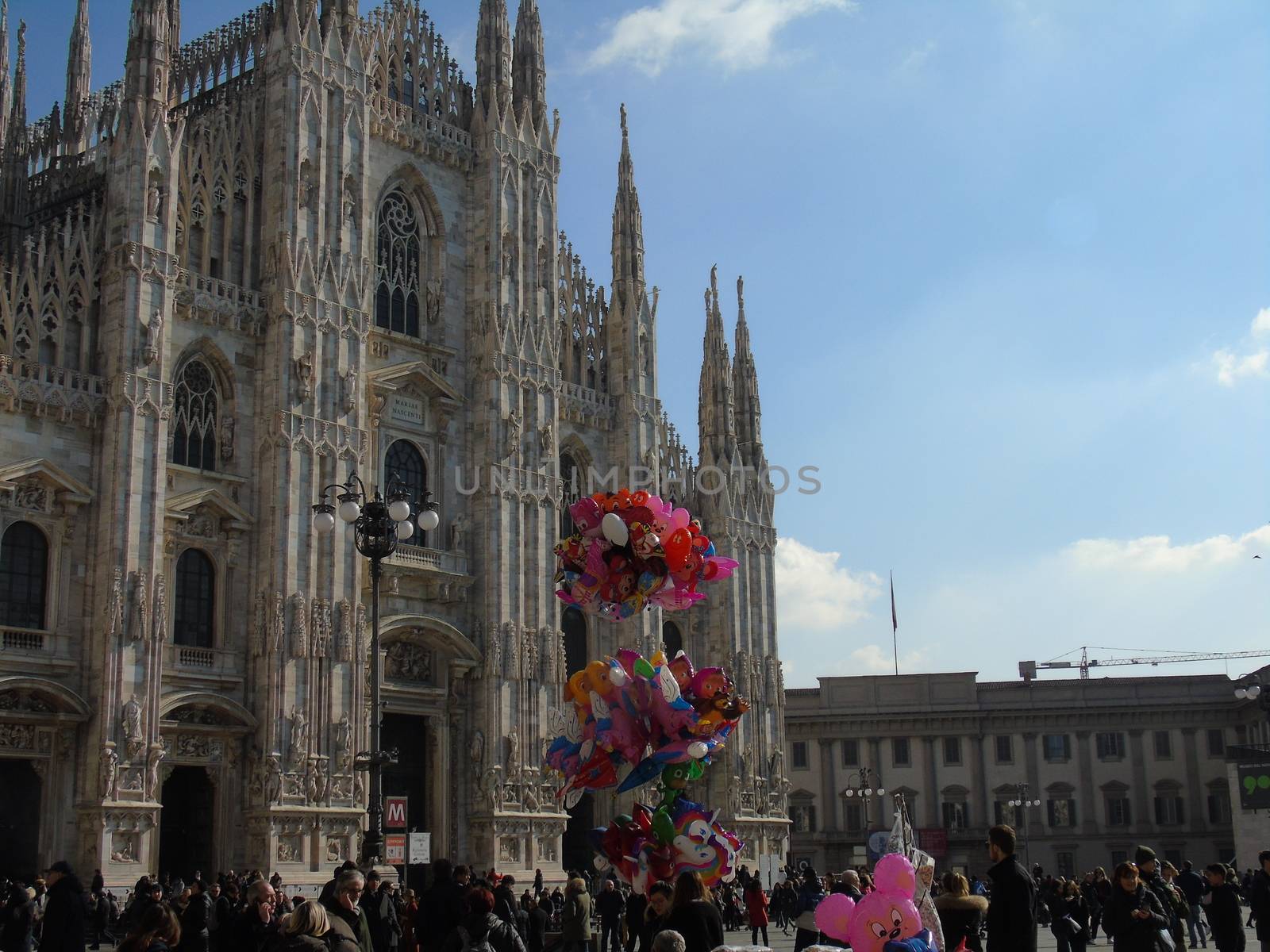 Milan, Italy - 02/01/2020: An amazing caption of the Duomo of Milan in winter days with some people enjoying the evening and beautiful coloured sky. Details of the old church from external part.