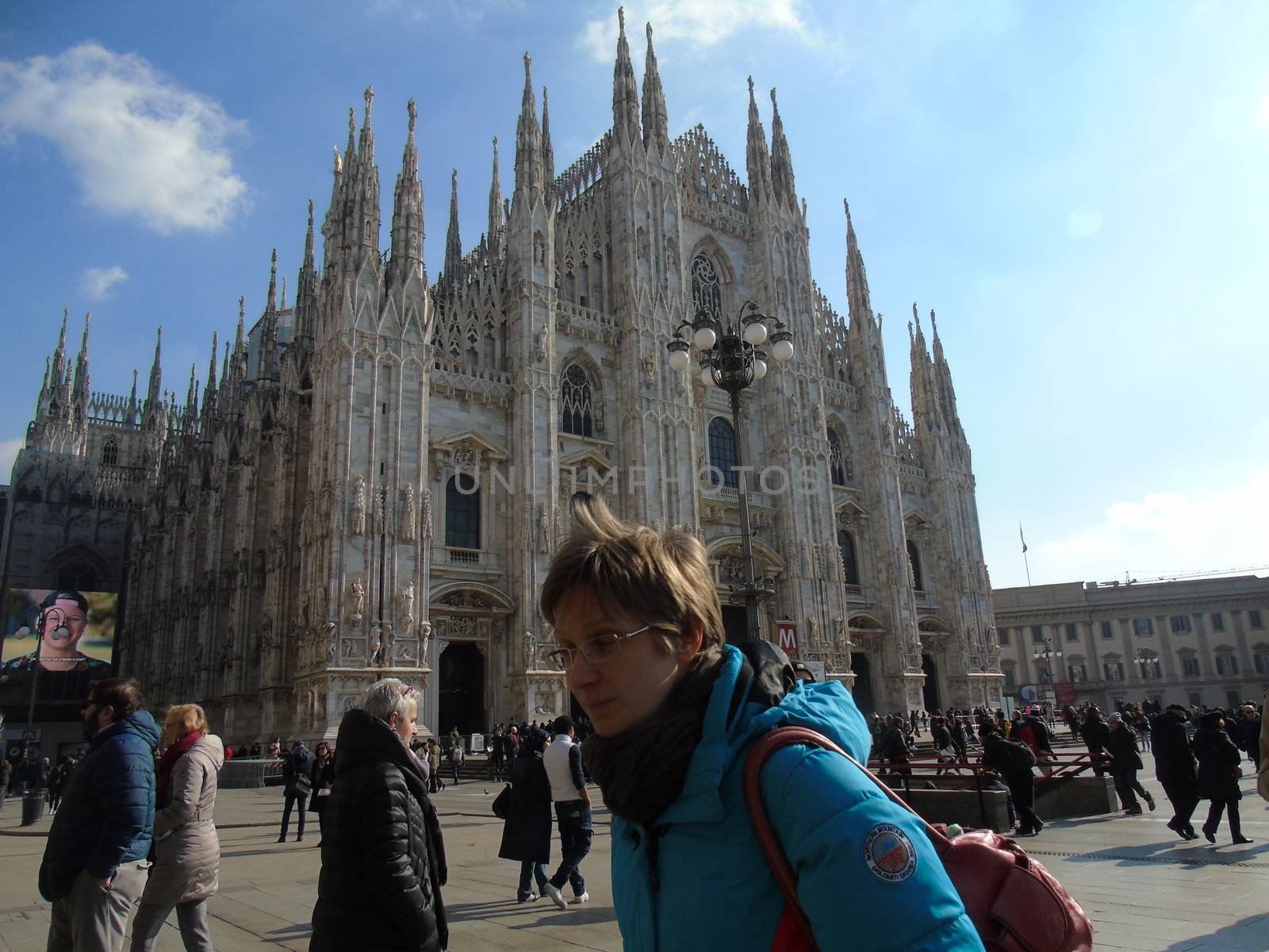 Milan, Italy - 02/01/2020: An amazing caption of the Duomo of Milan in winter days with some people enjoying the evening and beautiful coloured sky. Details of the old church from external part.