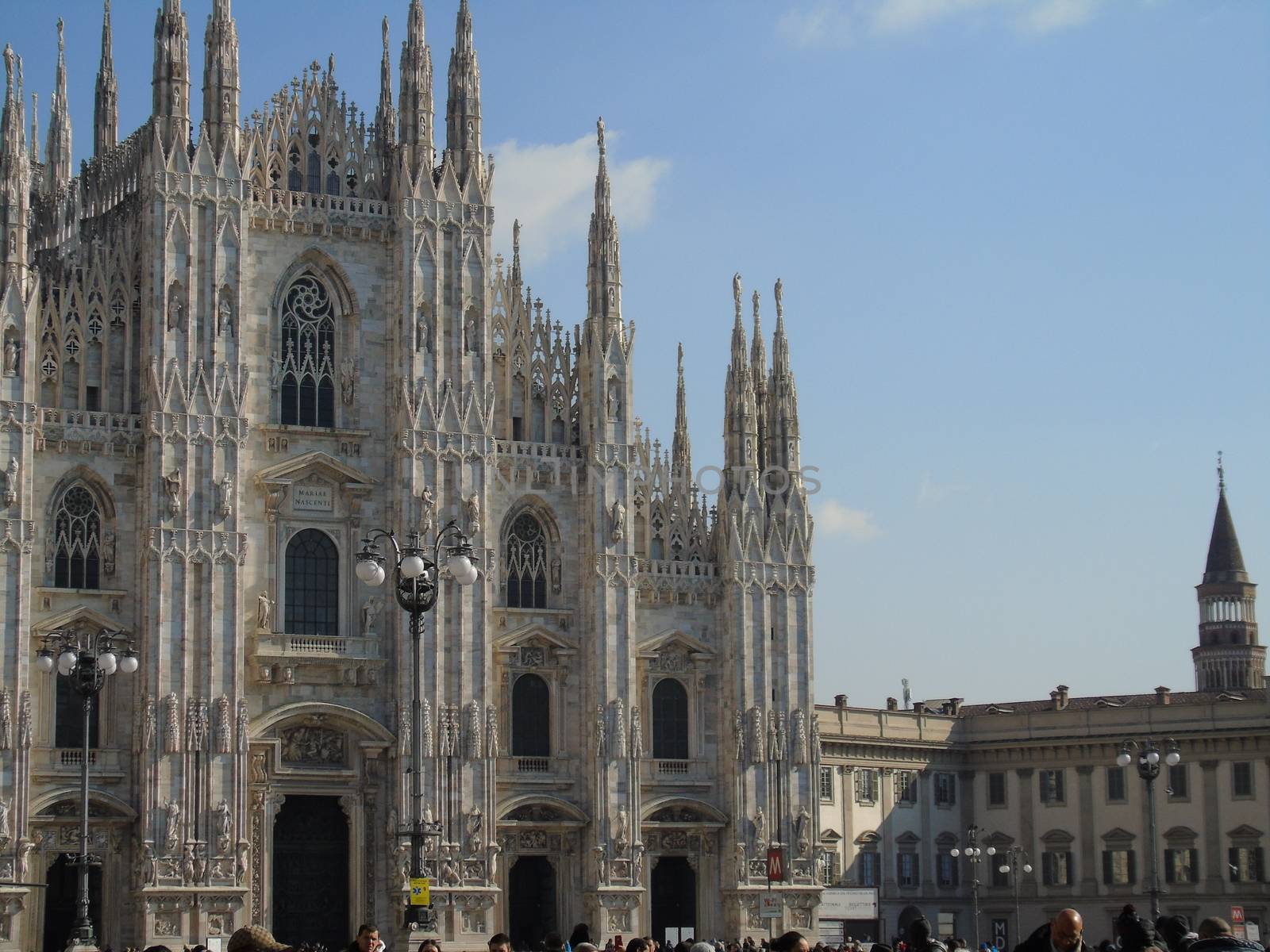 Milan, Italy - 02/01/2020: An amazing caption of the Duomo of Milan in winter days with some people enjoying the evening and beautiful coloured sky. Details of the old church from external part.