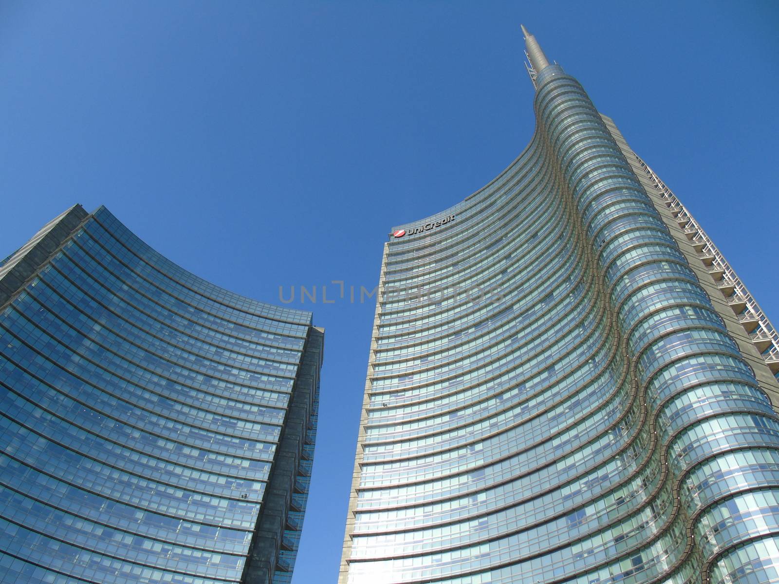 Milano, Italy - 02/14/2020: Amazing photography to the Skyscrapers of Milano in winter days with some people, a great blue sky and some details of the exterior part of the structure