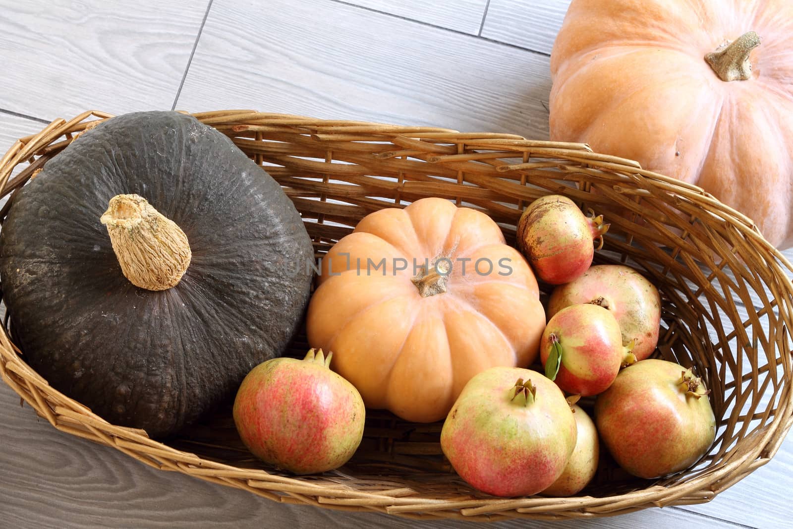 Basket with autumn pumpkins and pomegranates