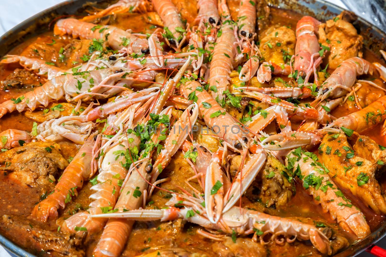 Paella with seafood and vegetables in a pan by Digoarpi