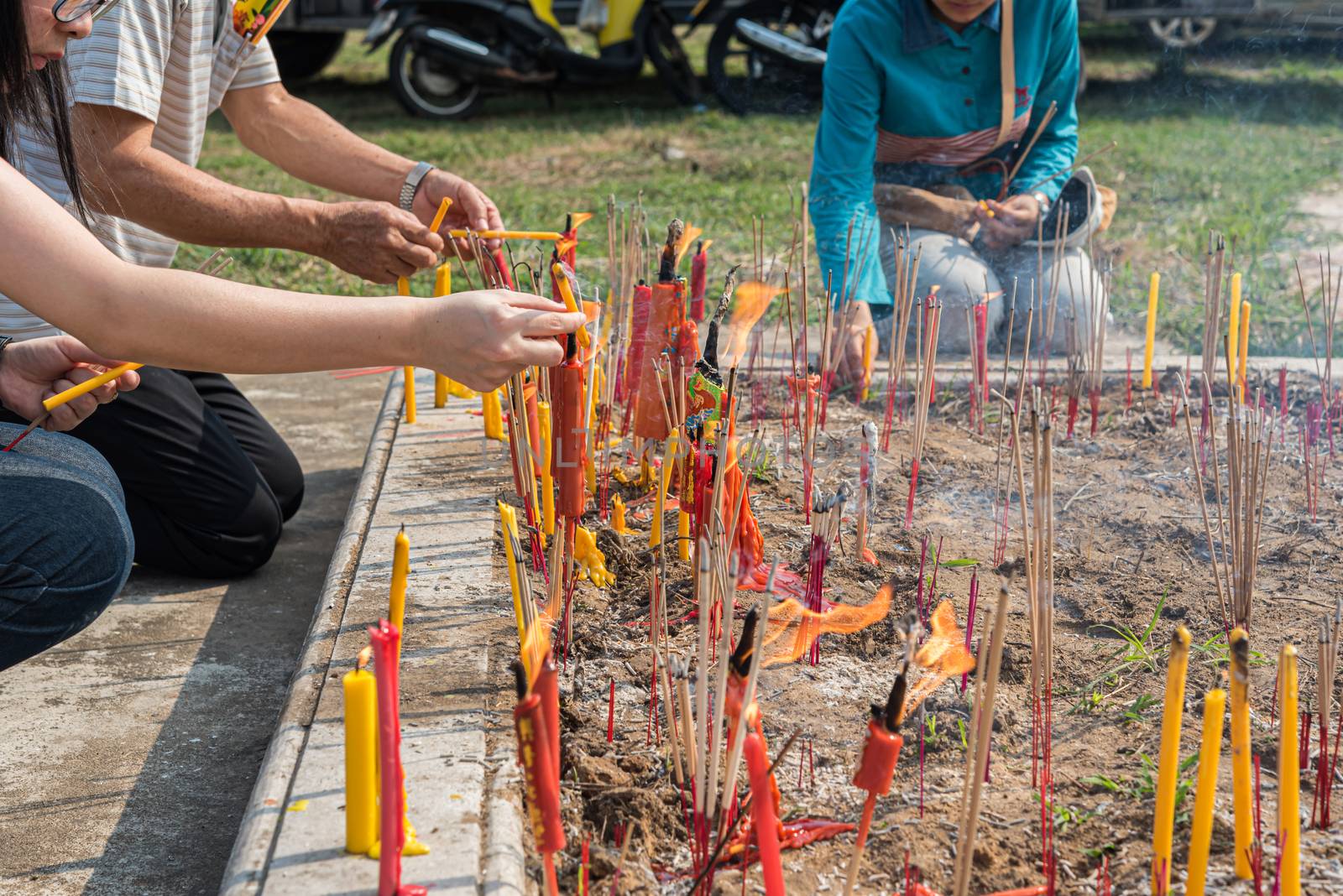 Prachinburi, Thailand - April 7, 2019 : Thai Chinese respect ancestors parents those died by food and burn fake money to sacrifice them at cemetery in Qingming Festival (Qing Ming), Tomb-Sweeping Day