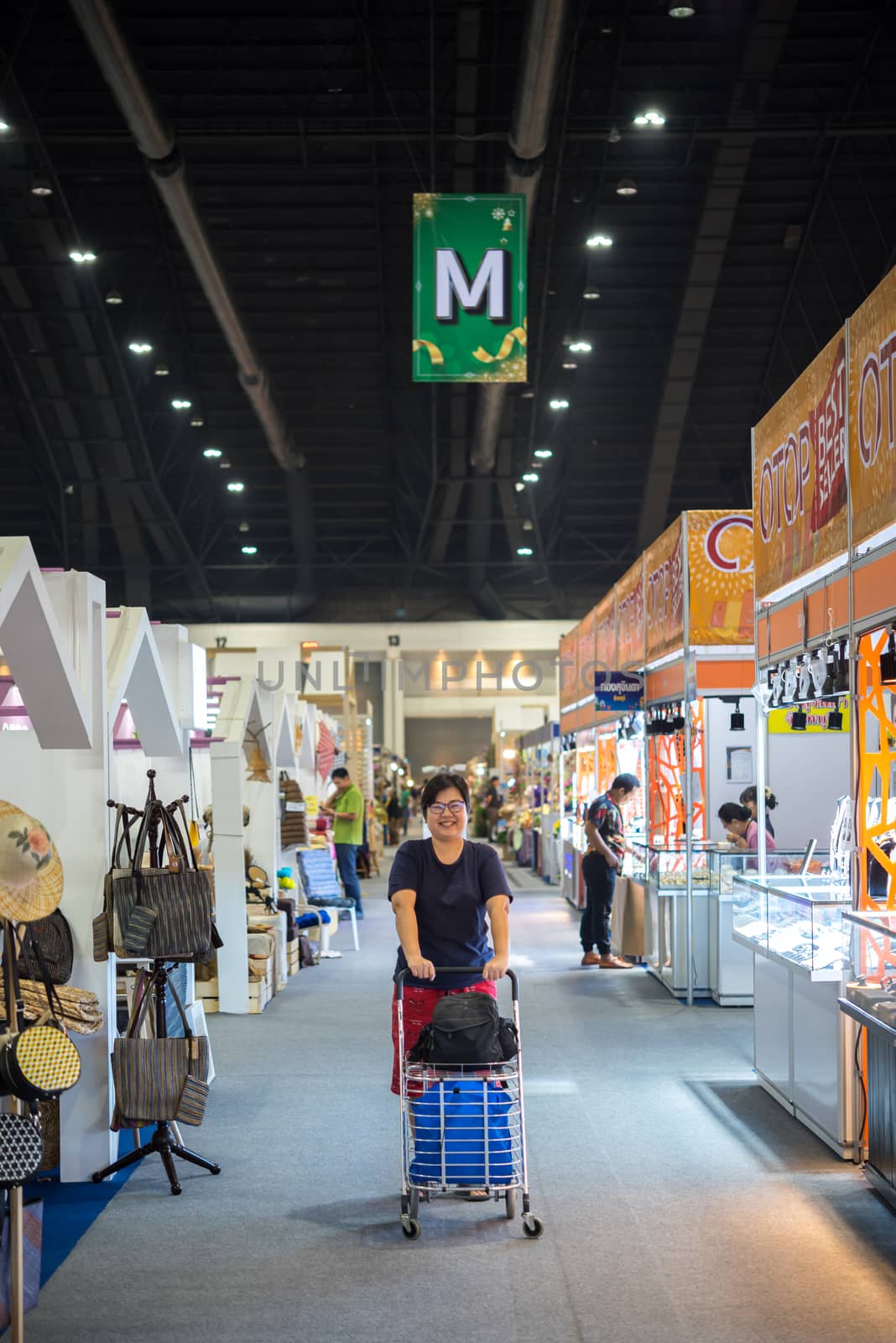 Bangkok, Thailand - December 21, 2019 : Unidentified asian woman feeling happy when her purchase a goods product in shopping cart in department store or exhibit hall expo OTOP