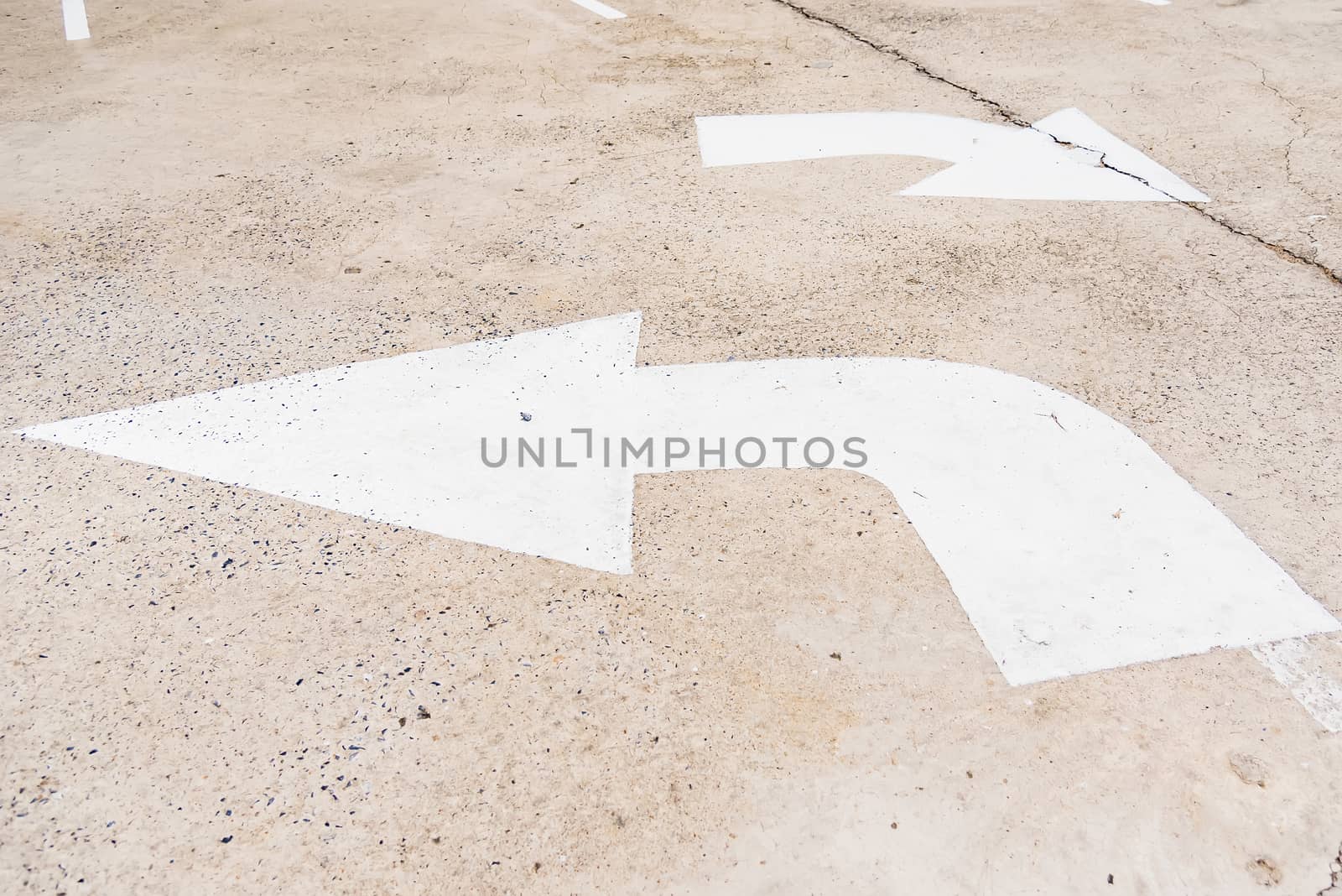 Arrow sign of turn, Old white painting on dirty concrete backgro by Bubbers
