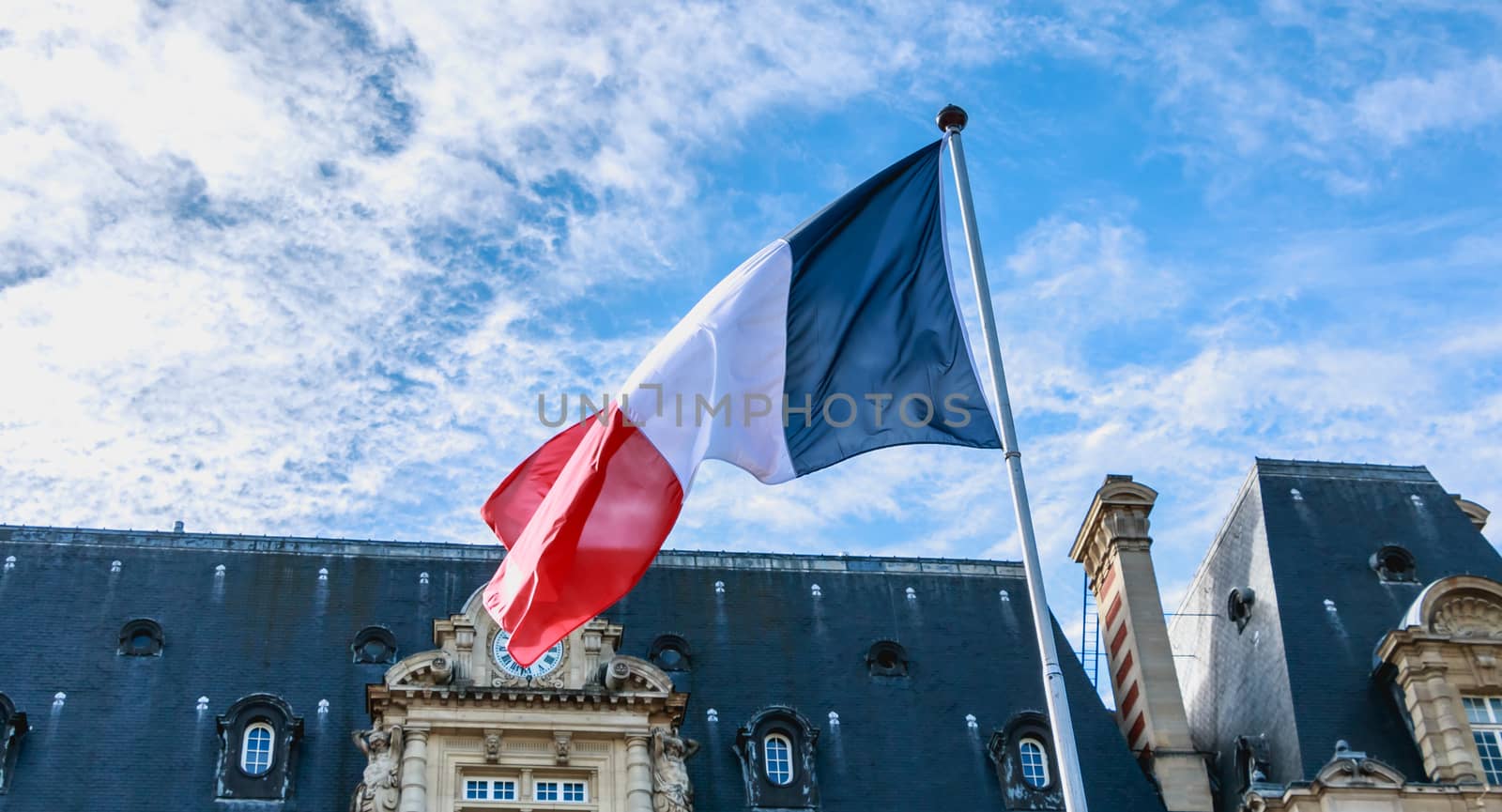 french flags flying in front of a building in France