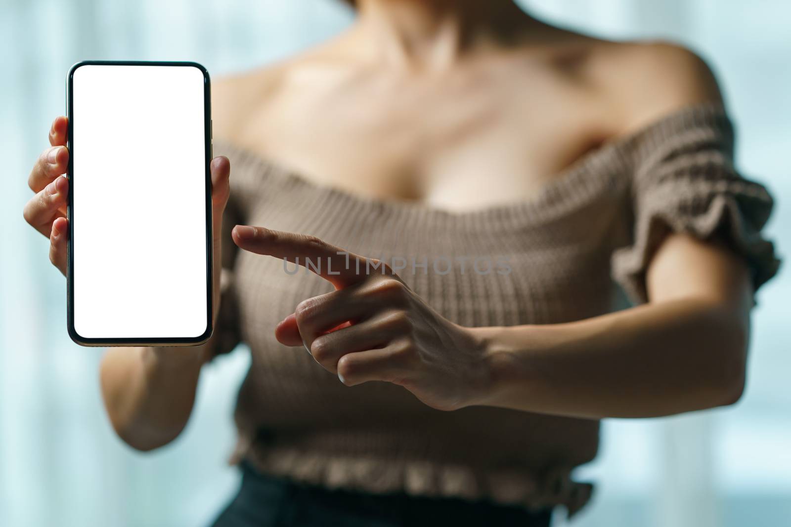 Sexy woman showing white blank display of her mobile phone.