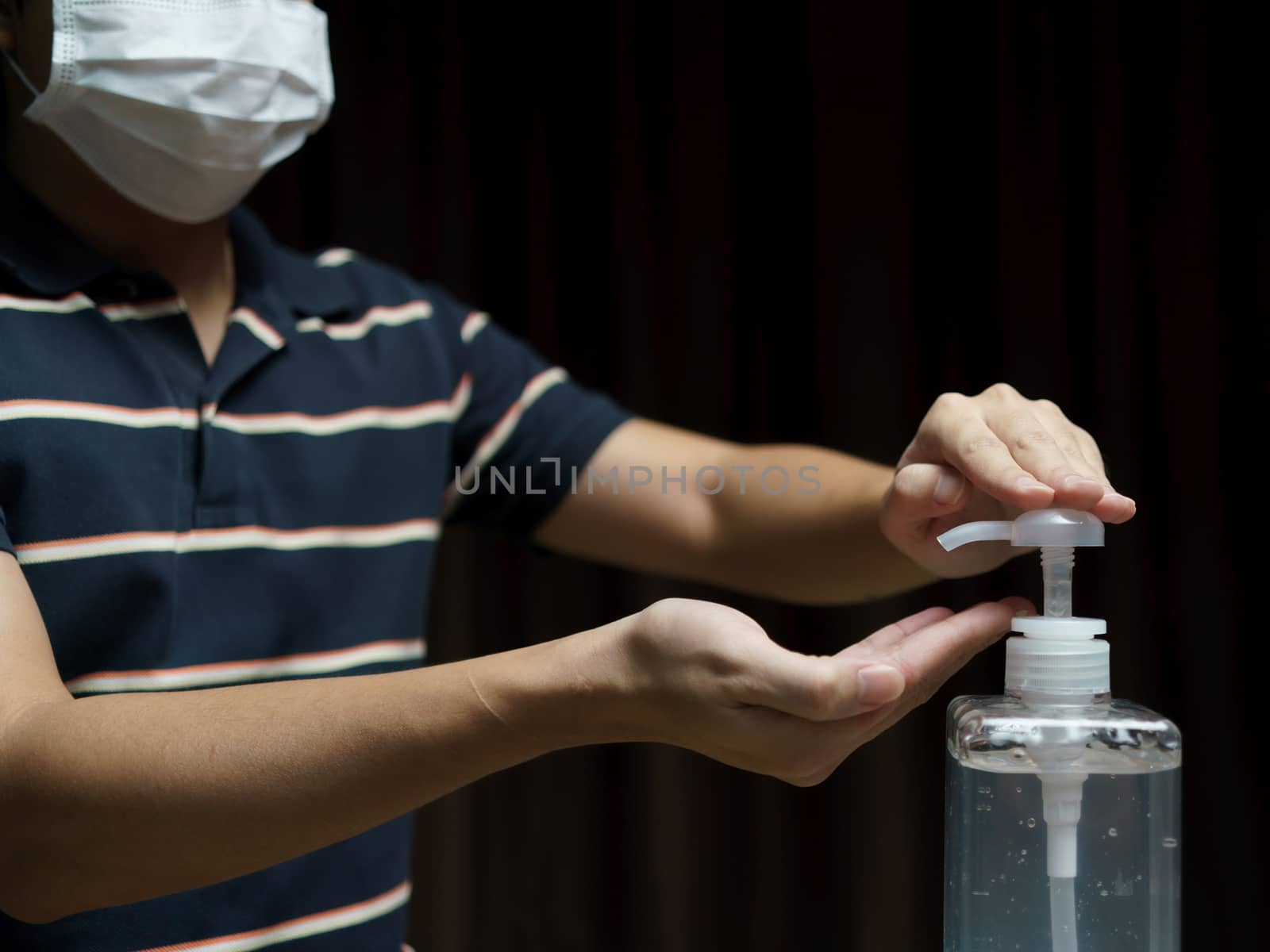 Man wear protective face mask cleaning his hands with sanitizer liquid antibacterial gel, in quarantine, corona virus concept.