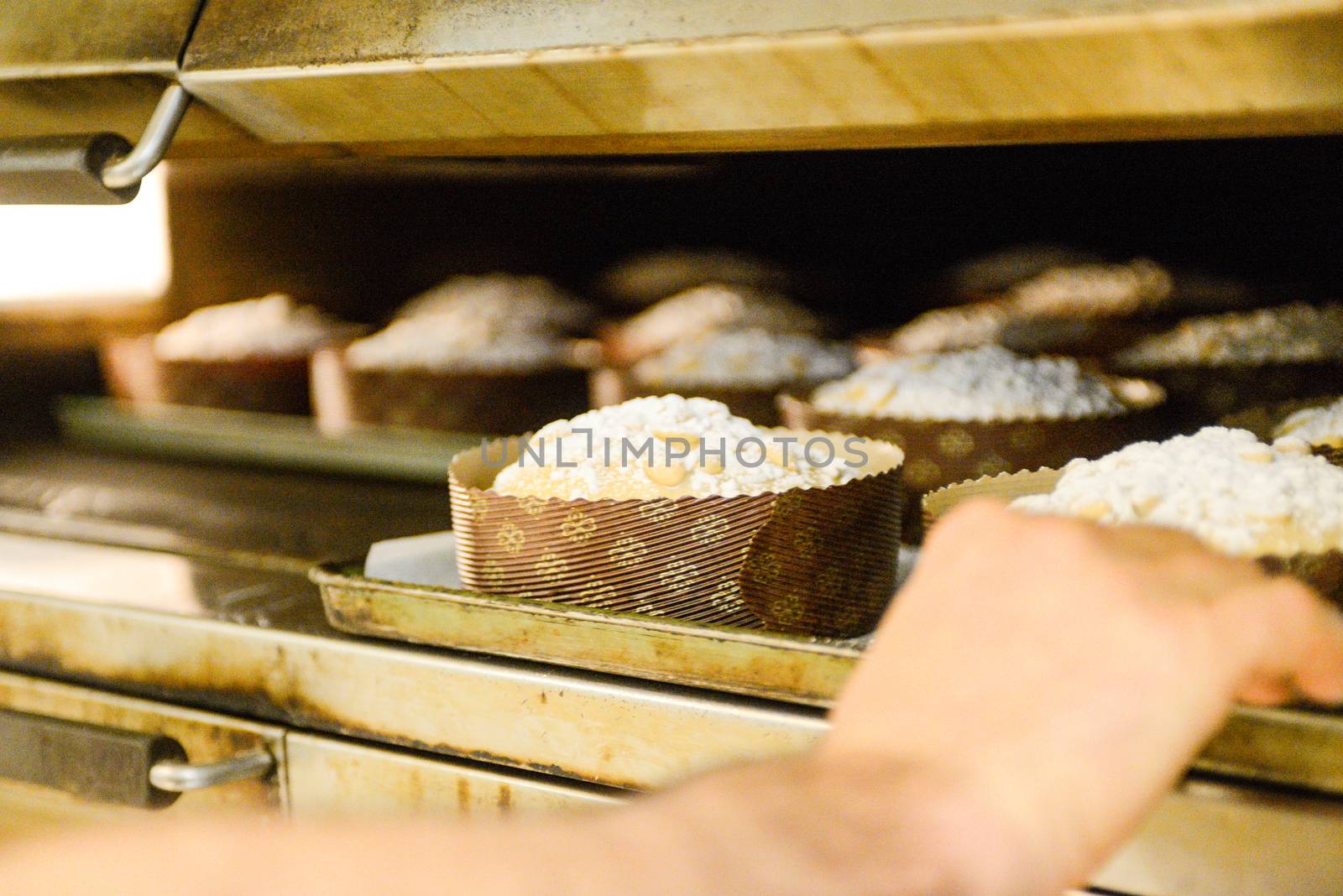 pastry chef in professional kitchen preparing and baking milanese panettone in christmas time. by verbano