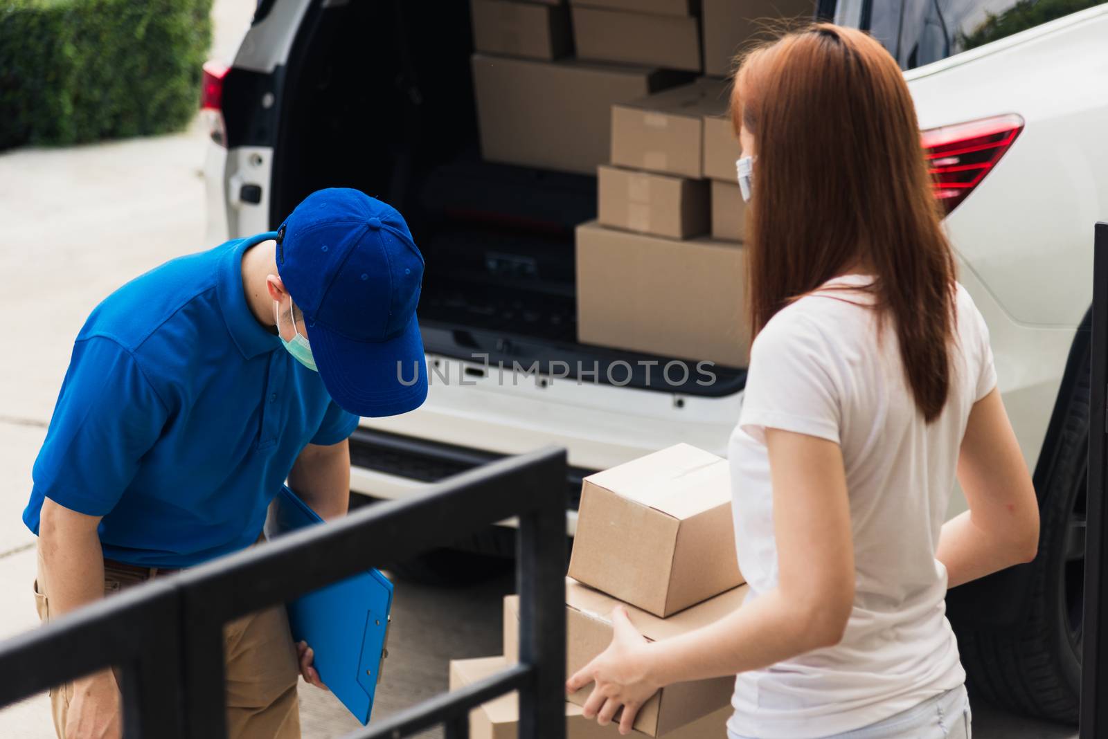 Asian young delivery man head around respect for thanks thank you woman customer use service both protective face mask under curfew quarantine pandemic coronavirus COVID-19 at front home door