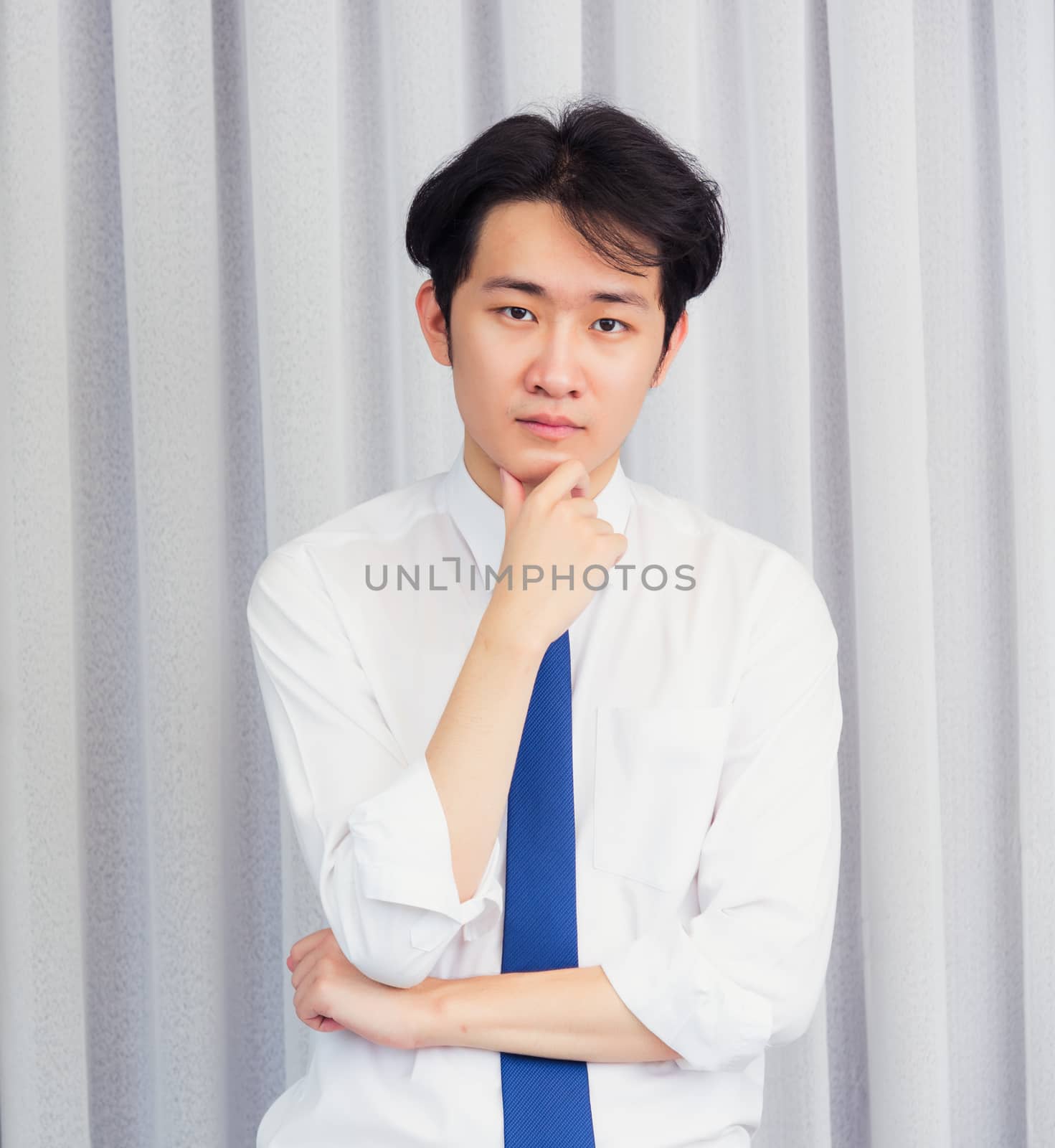 Portrait of happy business handsome man confident wearing shirt pose standing smiling looking to camera he take the hand to hold the chin