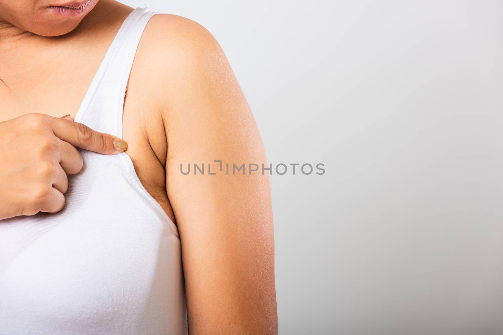 Close up of Asian woman pointing her skin underarm she problem armpit fat underarm wrinkled skin, problem armpit skin, studio isolated on white background, Healthy excess fat concept