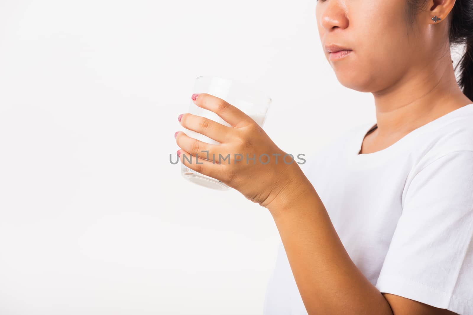 Asian portrait of happy young Asian beauty woman use hands hold drink white milk from a glass, studio shot isolated on white background, Food healthy care concept