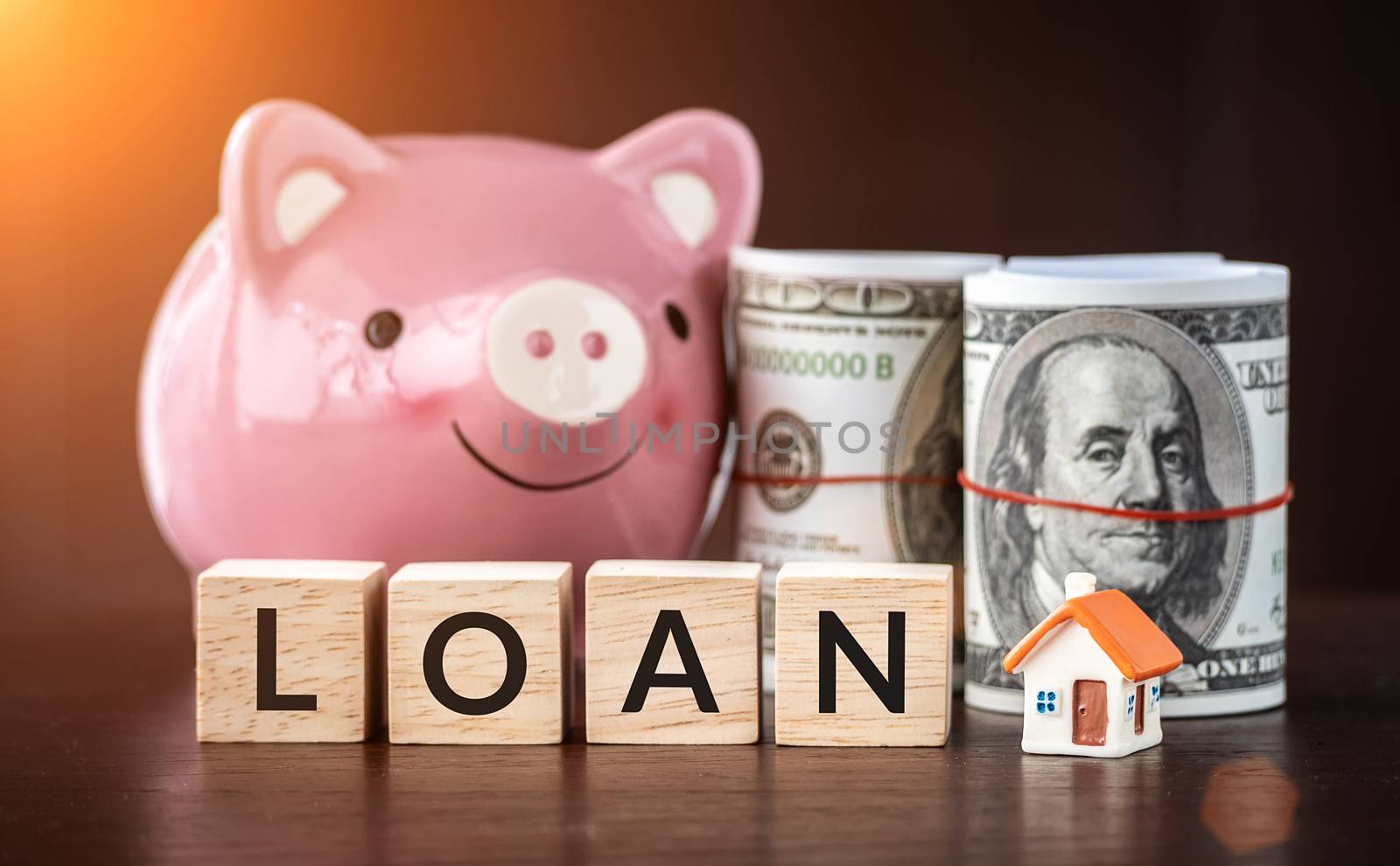 Real estate sale, savings, home loans market concept. model house with text loan on wooden cube, smilely pink Piggy bank and bank note by asiandelight