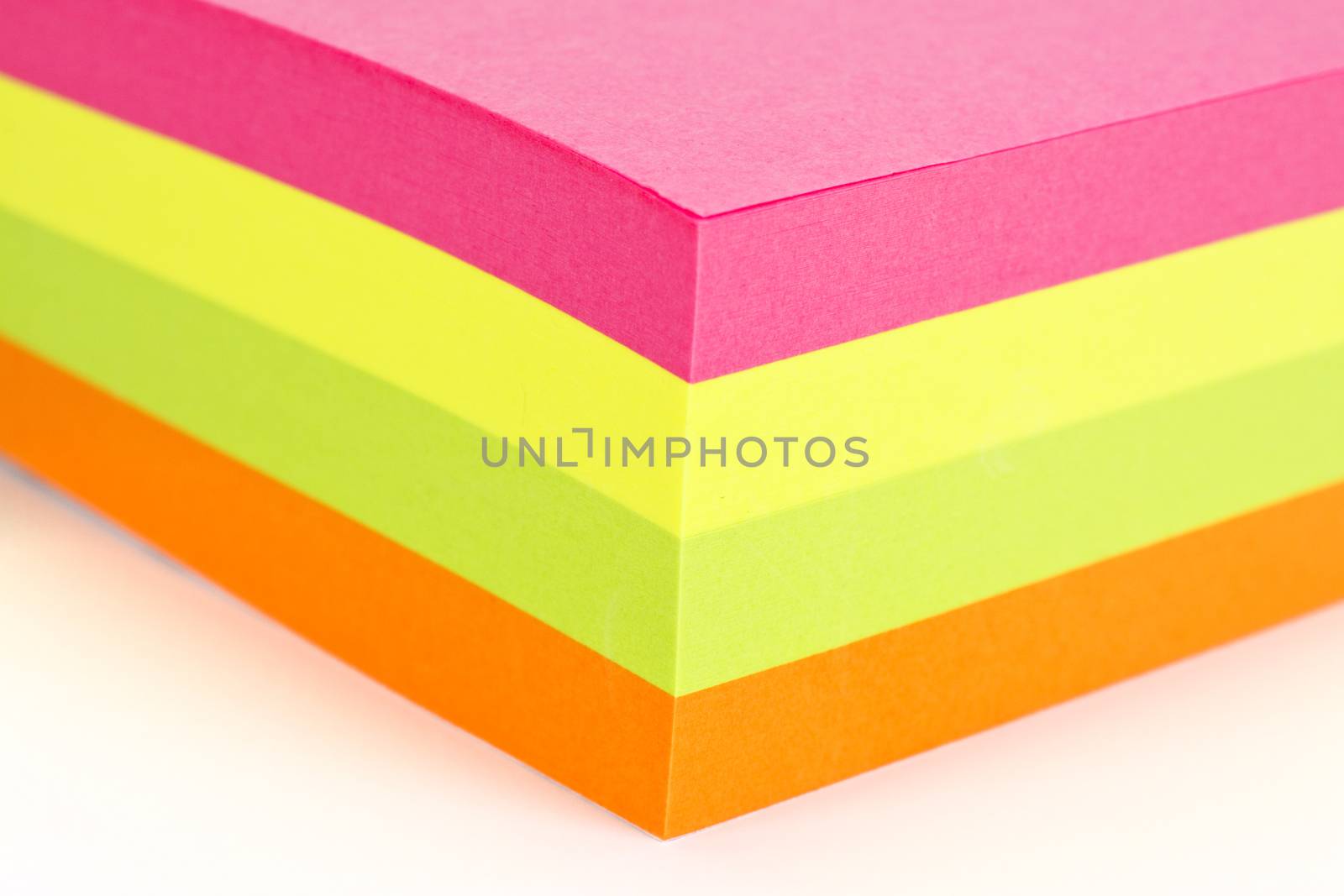 Multi colored sticky note isolated on white background.